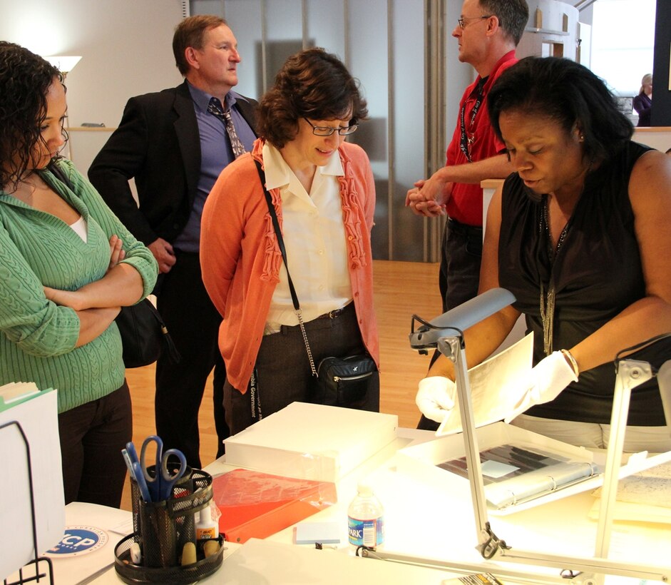 WASHINGTON  — The U.S. Army Corps of Engineers formally reopened its Washington, D.C.-area Veterans Curation Program (VCP) laboratory at its new location in Alexandria, Va., May 1. Devine Speights (right), an Army and Navy veteran and a participant in the Veterans Curation Program, explains details about the archaeological curation process to two attendees at the VCP Laboratory Open House. 