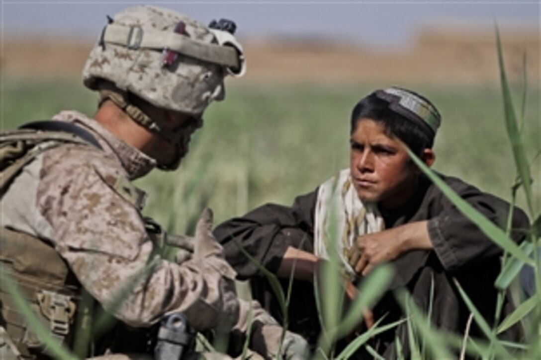 U.S. Marine Corps Lance Cpl. John Ellington talks to a local Afghan boy in Trek Nawa, Afghanistan, April 24, 2012. Ellington’s platoon partnered with Afghan soldiers in a clearing operation throughout the area. He is a team leader with Weapons Company, 2nd Battalion, 6th Marine Regiment.