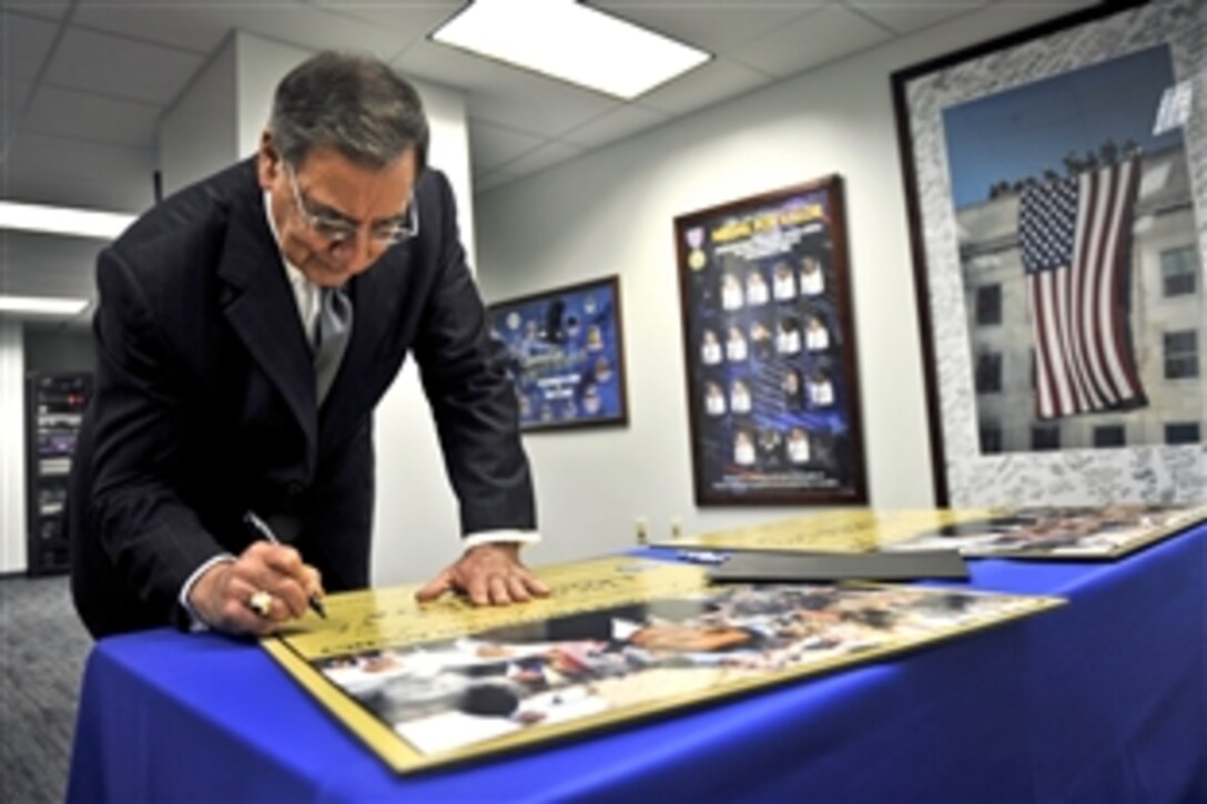 Defense Secretary Leon E. Panetta signs commemorative posters before the Pentagon Force Protection Agency's 10th anniversary event at the Pentagon, May 2, 2012. The agency was established on May 3, 2002, in response to the Sept. 11, 2001, terror attacks and the October 2001 anthrax attacks.