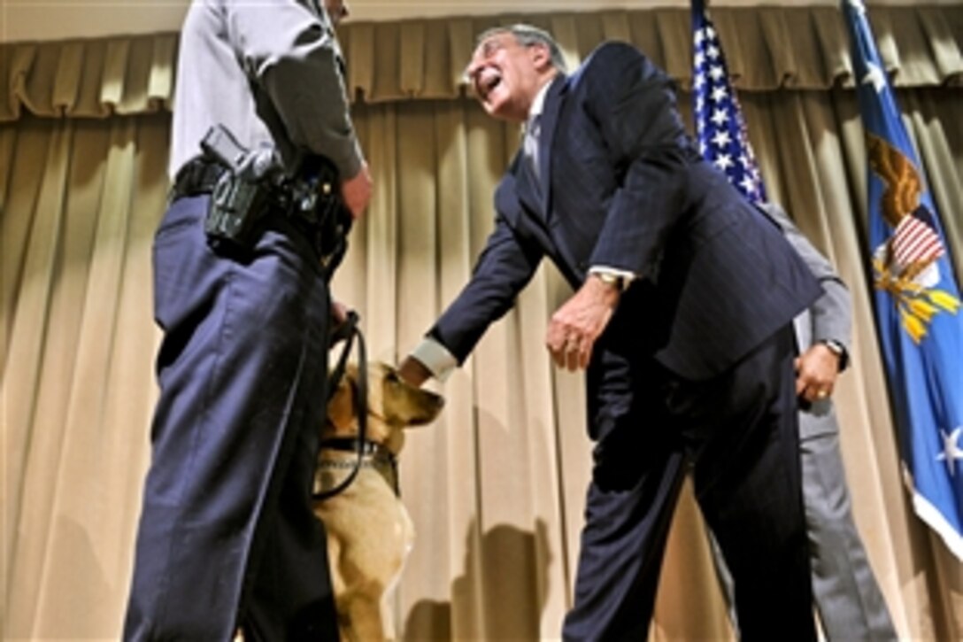 Defense Secretary Leon E. Panetta pauses to greet a police dog after receiving the Bravo Award from Jonathan H. Cofer, deputy director of the Pentagon Force Protection Agency, during the agency's 10th anniversary event at the Pentagon, May 2, 2012. The agency was established on May 3, 2002, in response to the Sept. 11, 2001, terror attacks and the October 2001 anthrax attacks.