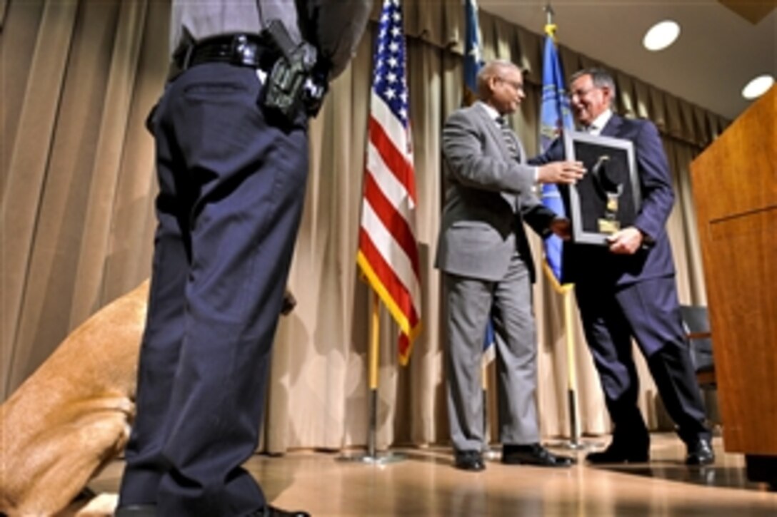Defense Secretary Leon E. Panetta receives the Bravo Award from Jonathan H. Cofer,deputy director of the Pentagon Force Protection Agency, during the agency's 10th anniversary event at the Pentagon, May 2, 2012. The agency was established as on May 3, 2002, in response to the Sept. 11, 2001, terror attacks and the October 2001 anthrax attacks.