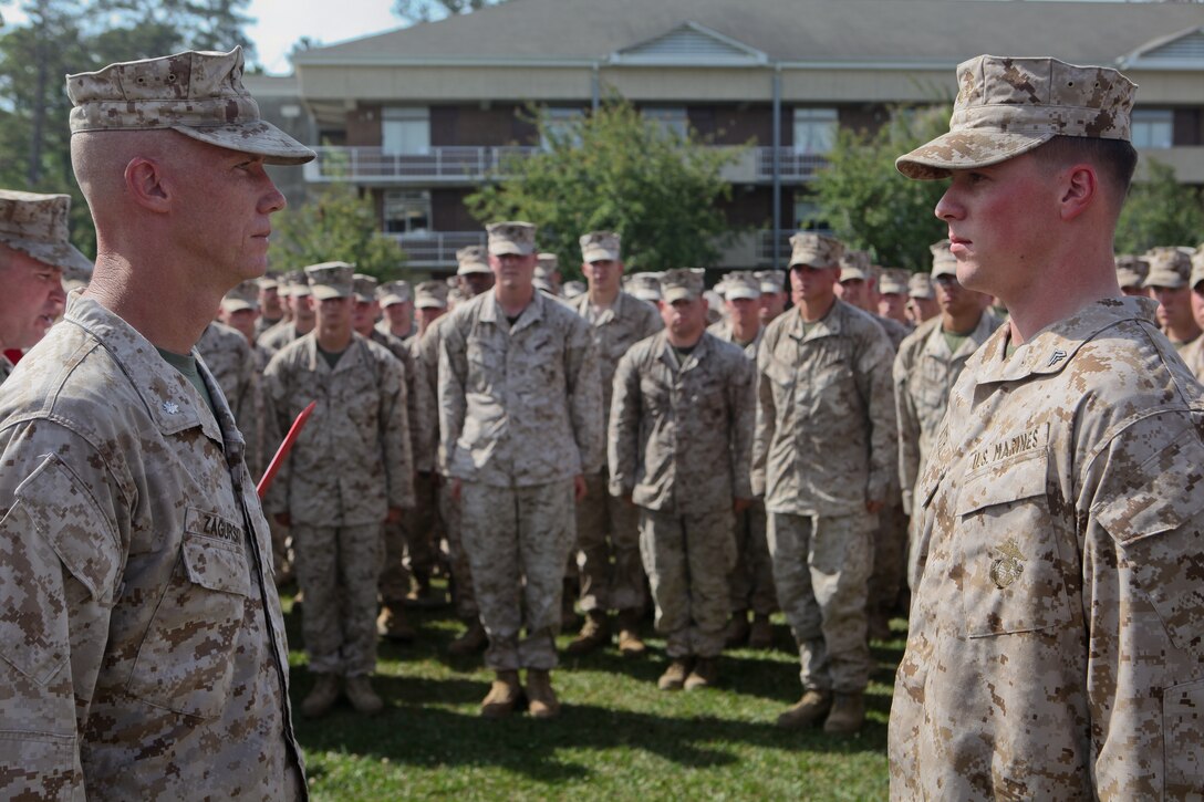 Lieutenant Col. Tyler Zagurski (left), commanding officer of 1st Battalion, 9th Marine Regiment, 2nd Marine Division, and a Mercer Island, Wash., native, stands opposite Cpl. Ronald Smith, a native of Saint Marys, Ga., and a mortarman with the unit, as the battalion sergeant major reads Smith’s Bronze Star medal with combat distinguishing device citation aloud May 4.  The ceremony was conducted at the conclusion of an 11-mile hike the battalion conducted to recognize Smith for treating a wounded Afghan soldier in the heat of combat in Helmand province, Afghanistan, last year. (Official U.S. Marine Corps photo by Cpl. Timothy L. Solano)