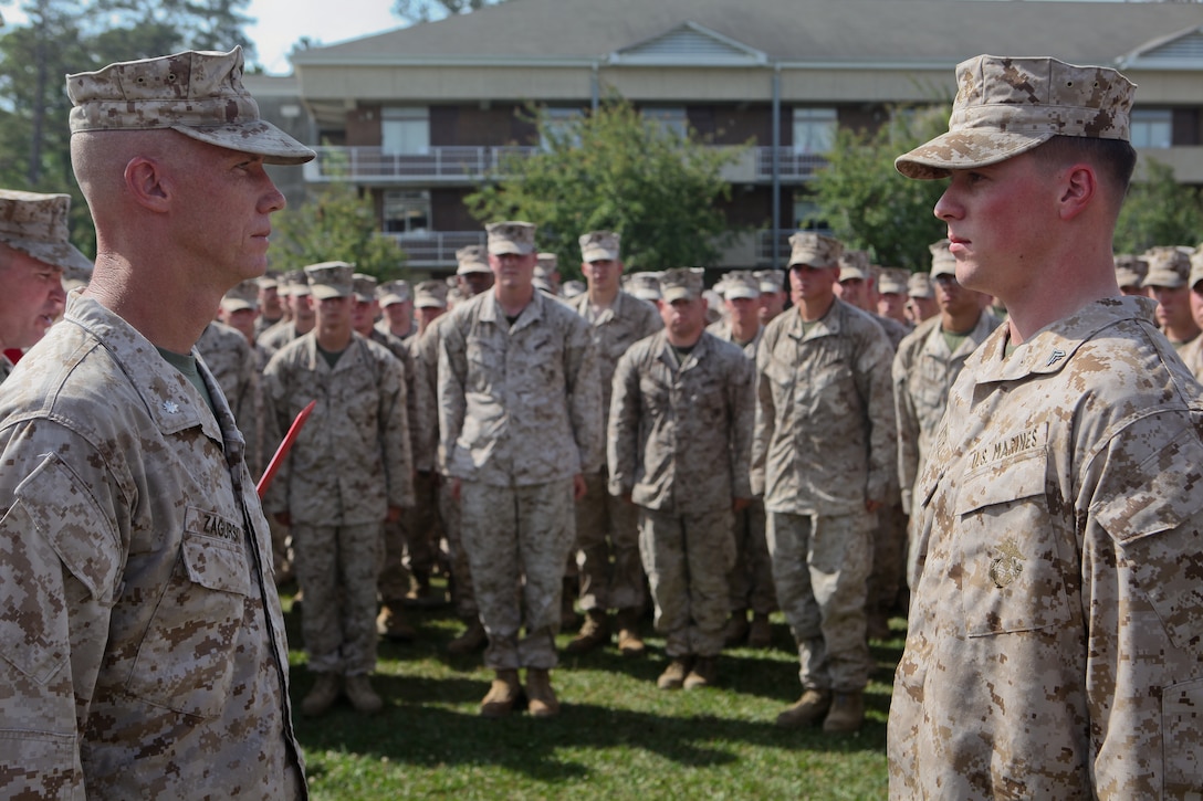 Lieutenant Col. Tyler Zagurski (left), commanding officer of 1st Battalion, 9th Marine Regiment, 2nd Marine Division, and a Mercer Island, Wash., native, stands opposite Cpl. Ronald Smith, a native of Saint Marys, Ga., and a mortarman with the unit, as the battalion sergeant major reads Smith’s Bronze Star medal with combat distinguishing device citation aloud May 4.  The ceremony was conducted at the conclusion of an 11-mile hike the battalion conducted to recognize Smith for treating a wounded Afghan soldier in the heat of combat in Helmand province, Afghanistan, last year. (Official U.S. Marine Corps photo by Cpl. Timothy L. Solano)