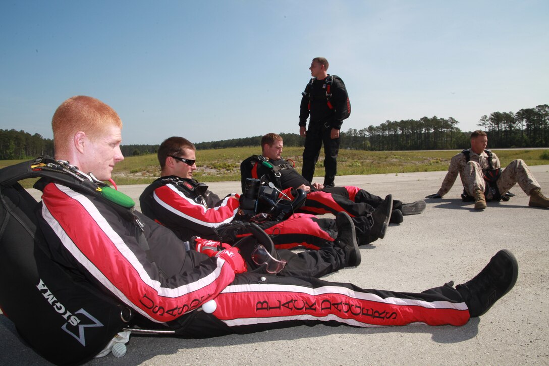 Two Marines from Marine Corps Air Station Cherry Point and soldiers with The United States Army Special Operations Command Black Daggers parachute demonstration team wait for their KC-130J to take them approximately 10,000 feet in the air for their tandem skydiving jump, May 3.  The two Marines were selected to go because of their ability to stand out in their squadrons as well as Marine Corps Air Station Cherry Point. The Marines, Cpl. Kyle Smith, a rescue diver with Marine Transport Squadron 1, and Cpl. Kevin Willis, an aircraft electronic countermeasures technician with Marine Tactical Electronic Warfare Squadron 4, plunged from approximately 10,000 feet with a Black Dagger soldier strapped to their backs.