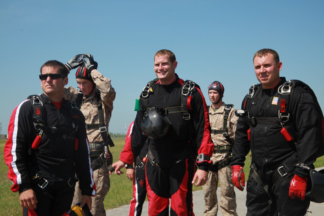 Two Marines from Marine Corps Air Station Cherry Point and soldiers with The United States Army Special Operations Command Black Daggers parachute demonstration team prepare to board the KC-130J to complete their tandem skydive. The Marines, Cpl. Kyle Smith, a rescue diver with Marine Transport Squadron 1, and Cpl. Kevin Willis, an aircraft electronic countermeasures technician with Marine Tactical Electronic Warfare Squadron 4, both fell from approximately 10,000 feet with a USASOC soldier strapped to their backs.