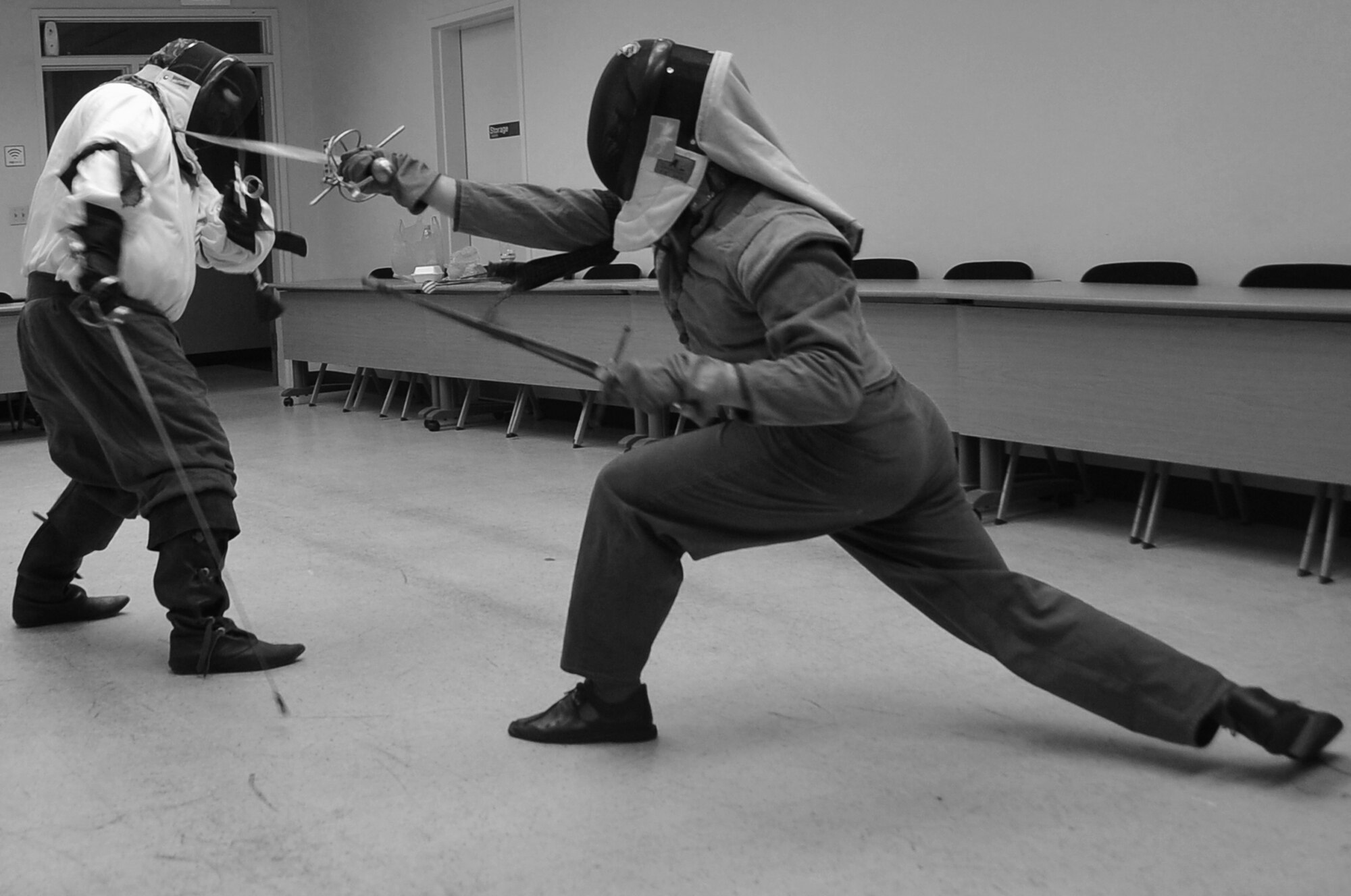 Senior Master Sgt. Christopher Raynor (right), 51st Civil Engineer Squadron deputy fire chief, thrusts at his opponent at Osan Air Base, Republic of Korea, May 2, 2012. Raynor has been instructing Airmen and others at Osan on proper form as well as offensive and defensive postures during a weekly session in the martial arts of medieval fencing. The class is held on Wednesdays in the Community Center from 7 -10 p.m. Students practice different styles, including single point, sword and dagger, and sword and cloak. (U.S. Air Force photo/Staff Sgt. Craig Cisek) 