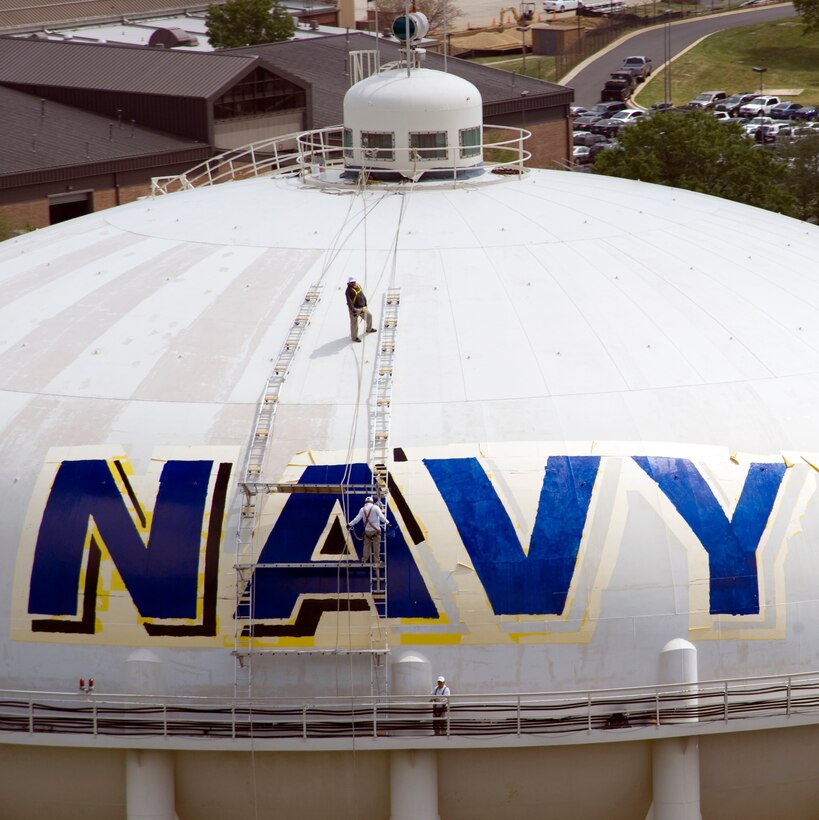 A team of contractors paint Navy signage on the main water tower at Joint Base Andrews April 18. Tentative plans include adding official Marine signage to the tower. (Photo/Bobby Jones) 