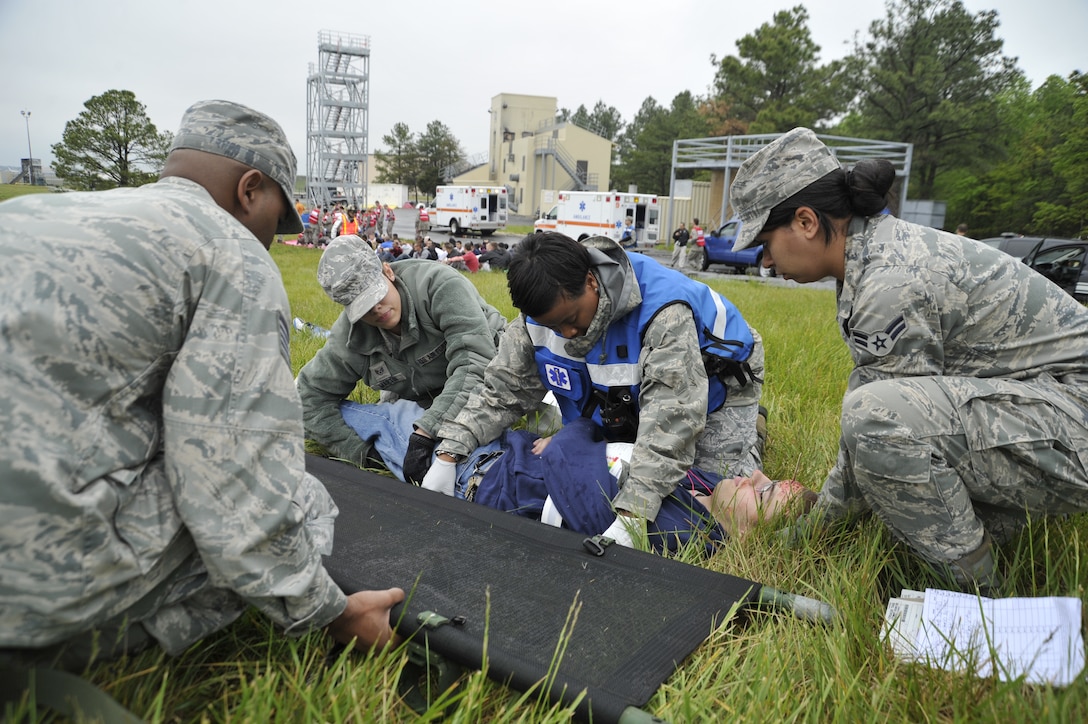 Medics from the 79th Medical Wing roll a simulated patient onto a litter during Exercise Sysyphus on April 26. Simulated patients and casualties helped prepare those involved in the exercise in case of a possible incident at the upcoming Andrews Joint Service Open House and Air Show. (U.S. Air Force photo/Senior Airman Perry Aston)