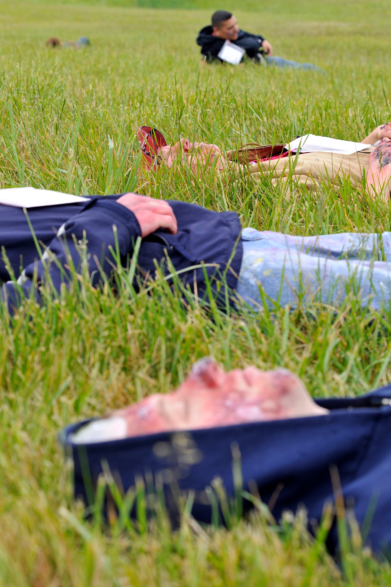 Four out of the 100 simulated casualties lie in the grass during Exercise Sisyphus on April 26. The exercise tests the response capability of all those involved in the event of a real-world mass casualty incident during the upcoming Andrews Joint Service Open House and Air Show. (U.S. Air Force photo/Senior Airman Perry Aston)