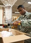 Airman 1st Class Derek Barbour, 28th Logistics Readiness Squadron packing and crating technician, pours packing peanuts into a box during the packing of an aircraft part at Ellsworth Air Force Base, S.D., May 1, 2012. Barbour filled the box with packing peanuts to cushion the aircraft part and ensure it was undamaged during shipment. (U.S. Air Force photo by Airman 1st Class Alystria Maurer/Released)