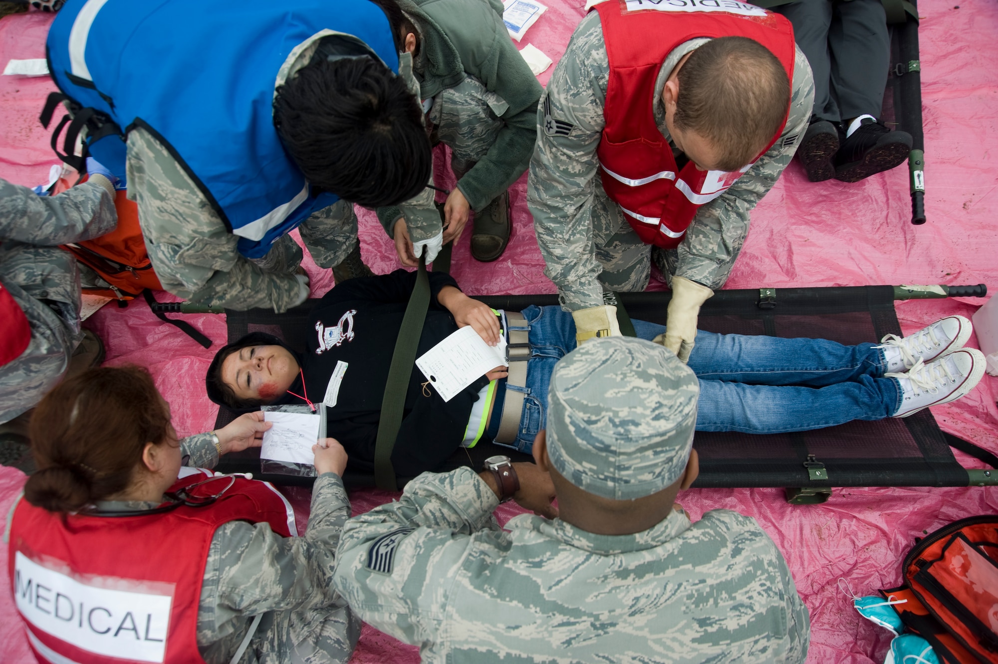 79th Medical Wing medical members simulate stabilizing an injured patient before transporting her to a local community hospital during a mass casualty exercise held on Joint Base Andrews on April 26. (Photo/Bobby Jones)