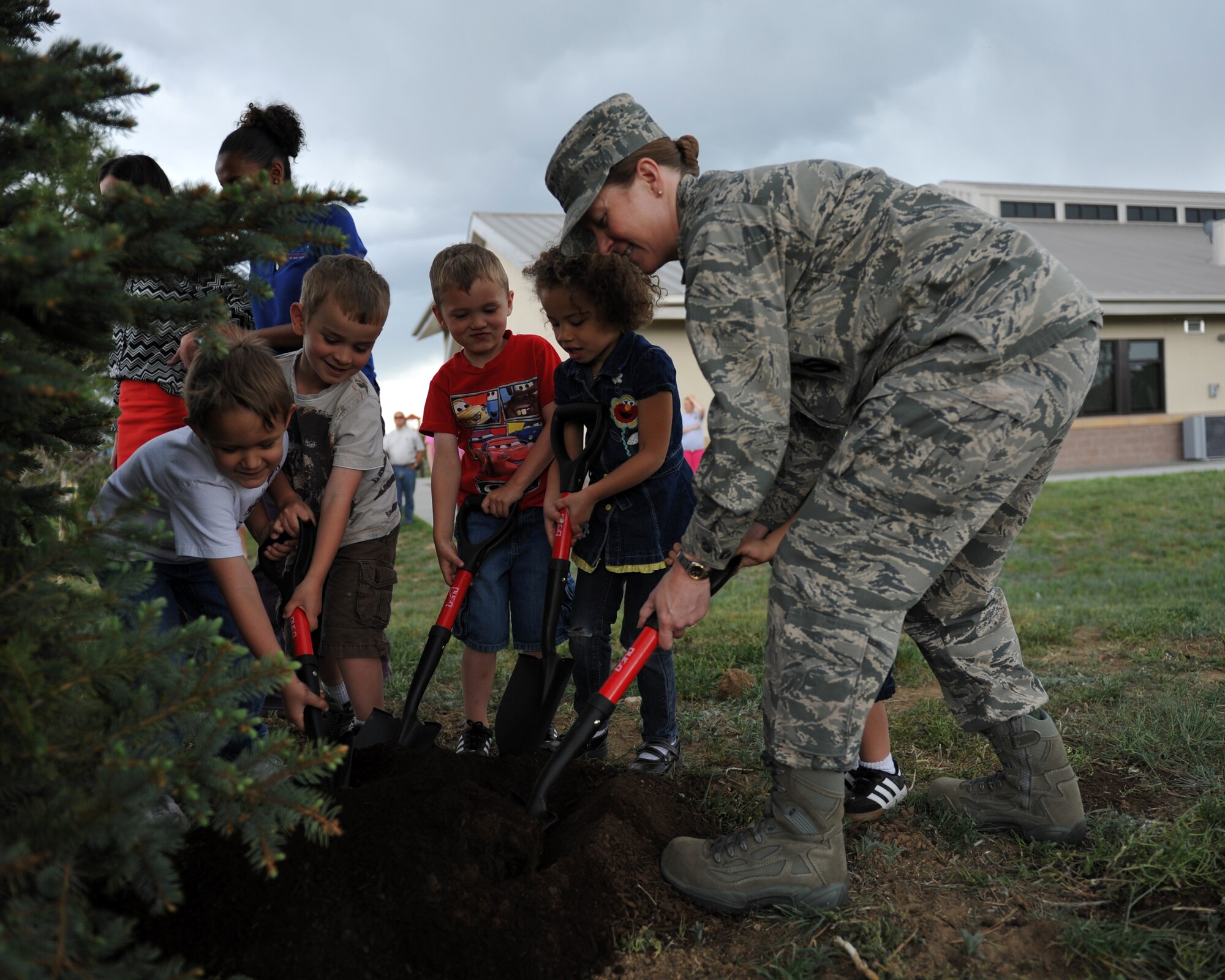 BUCKLEY AIR FORCE BASE, Colo. – Col. Tracey Hayes, 460th Space Wing vice commander, helps children plant a tree for Arbor Day, April 26, 2012. The Buckley Child Development Center and Buckley leadership helped raise awareness for the environment. (U.S. Air Force photo by Airman 1st Class Darryl Bolden Jr.)