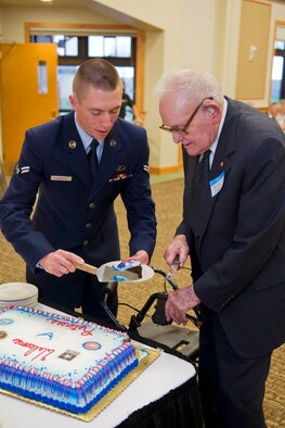 Airman 1st Class Gabriel Zambrano, 341st Logistics Readiness Squadron, assists retired Lt. Col. Harold Floyd in getting a piece of cake following dinner. (U.S. Air Force photo/Beau Wade)