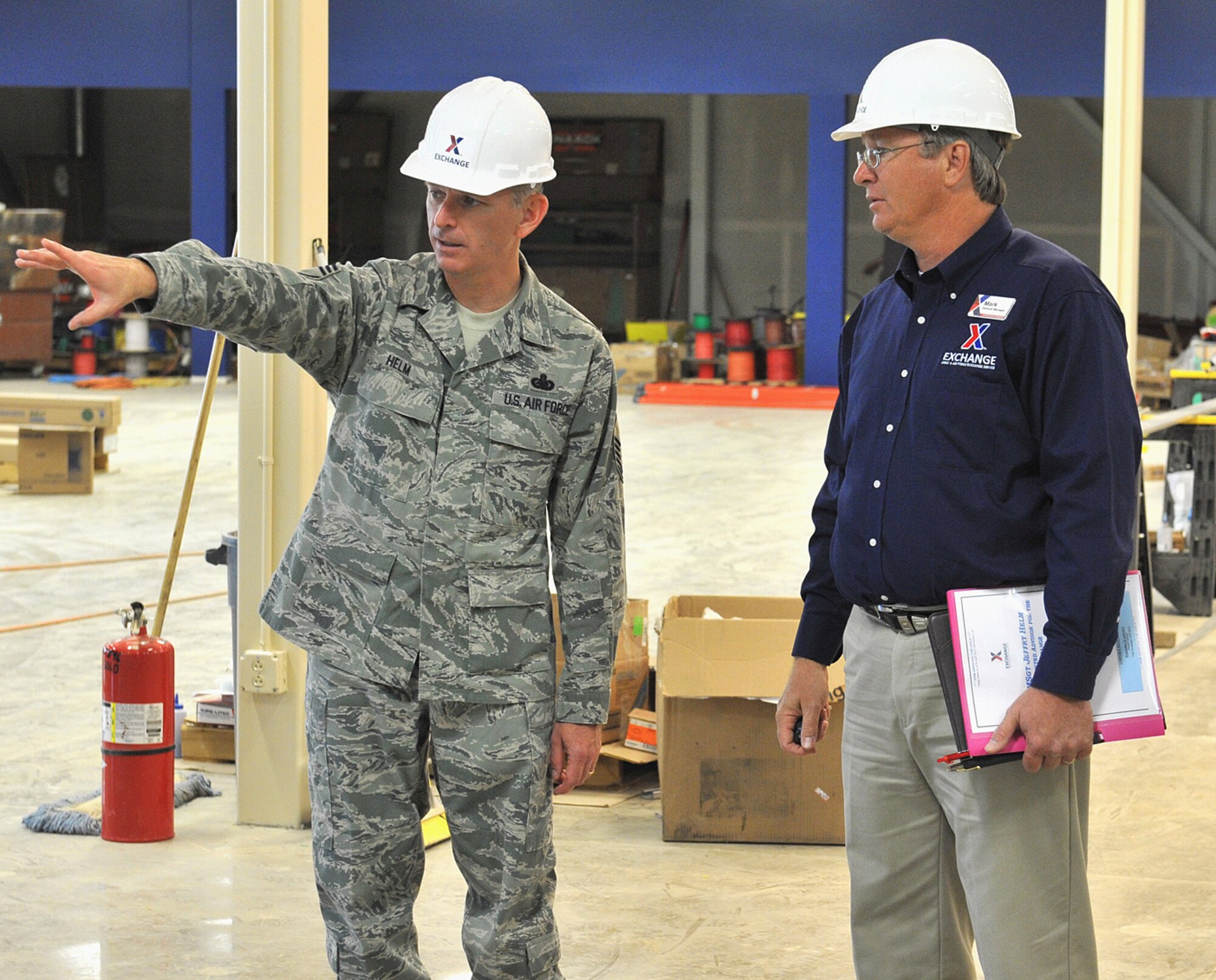 Chief Master Sgt. Jeffrey Helm, AAFES senior enlisted advisor, asks a question of Base Exchange Manager Mark Downs, while the two were touring the new exchange facility April 26. The new facility is slated to open in July of this year. (U.S. Air Force photo/John Turner)