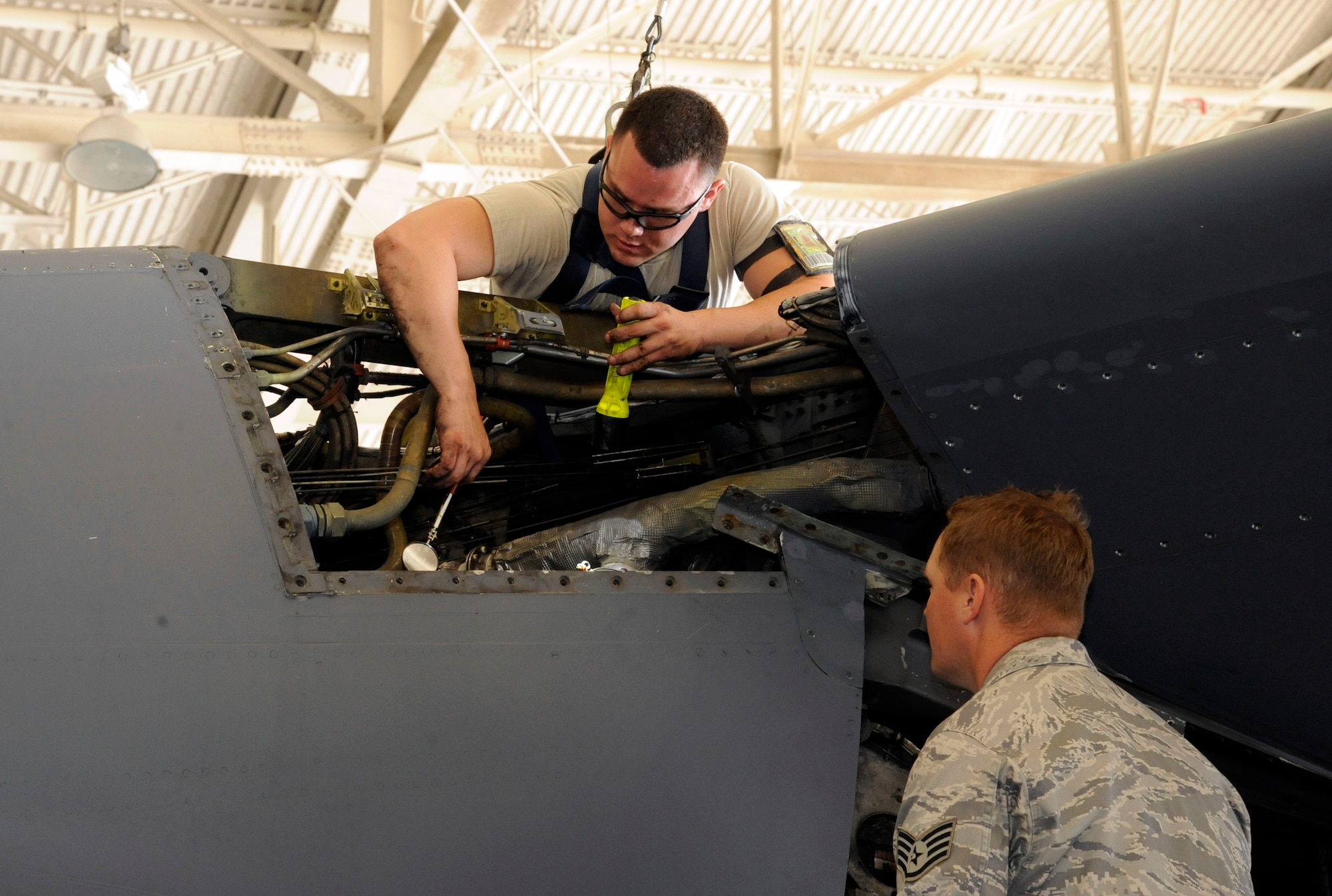 Senior Airman Greg Pagallo, 2nd Maintenance Squadron, inspects the throttle cables on the number two pod kneecap of a B-52H Stratofortress as Staff Sgt. Matt Lachney, 2 MXS, observes inside the Phase Hangar on Barksdale Air Force Base, La., May 1. These cables provide power to the landing gear and to the structures that flex the wings upward during flight. (U.S. Air Force photo/Airman 1st Class Andrew Moua)(RELEASED)