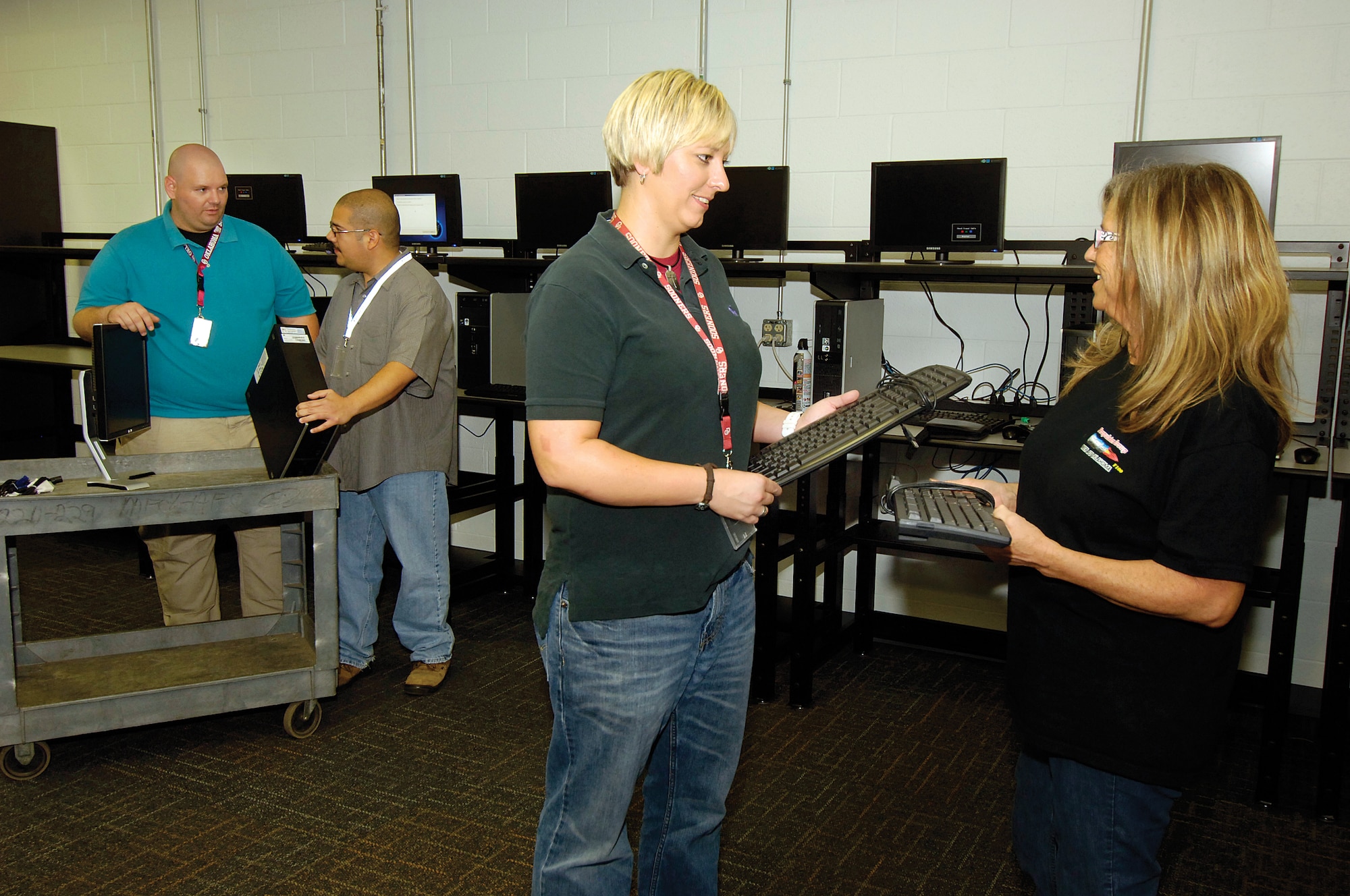 The new 72nd Communications Directorate Consolidated Services Center officially opens today in Bldg. 9001 Post DD46. Having computer assistance and replaceable parts available in a convenient center will reduce down-time when computer problems would stall mechanics’ work. Equipment custodian Kendall Kingsbury, center, works with TF-33 mechanic Mitzie Parmeter, right, and equipment custodian Ted Solis assists F100 Augmenter jet engine reworker Joe McGehee, far left, in the new center.  Service center personnel can get 9001 workers back up and running within the hour instead of days. (Air Force photo by Margo Wright)