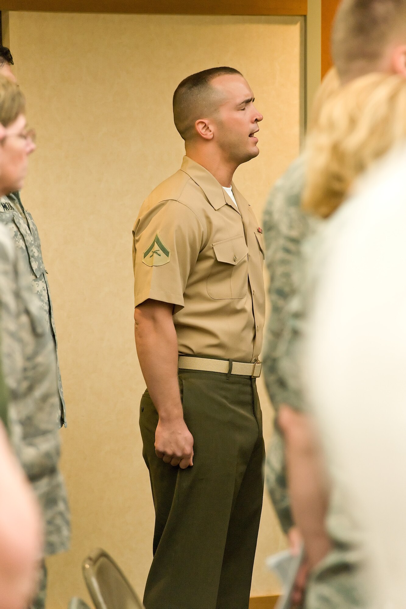 Marine Lance Cpl. Landon Beaty, a Marine liaison at the Charles C. Carson Center for Mortuary Affairs, sings the National Anthem at the Air Force Mortuary Affairs Operations Change of Command ceremony May 2, 2012 at Dover Air Force Base, Del. Col. Thomas Joyce relinquished command to Col. John Devillier. Lt. Gen. Darrell Jones, Deputy Chief of Staff, Manpower, Personnel and Services, officiated the ceremony. (U.S. Air Force photo/Roland Balik)