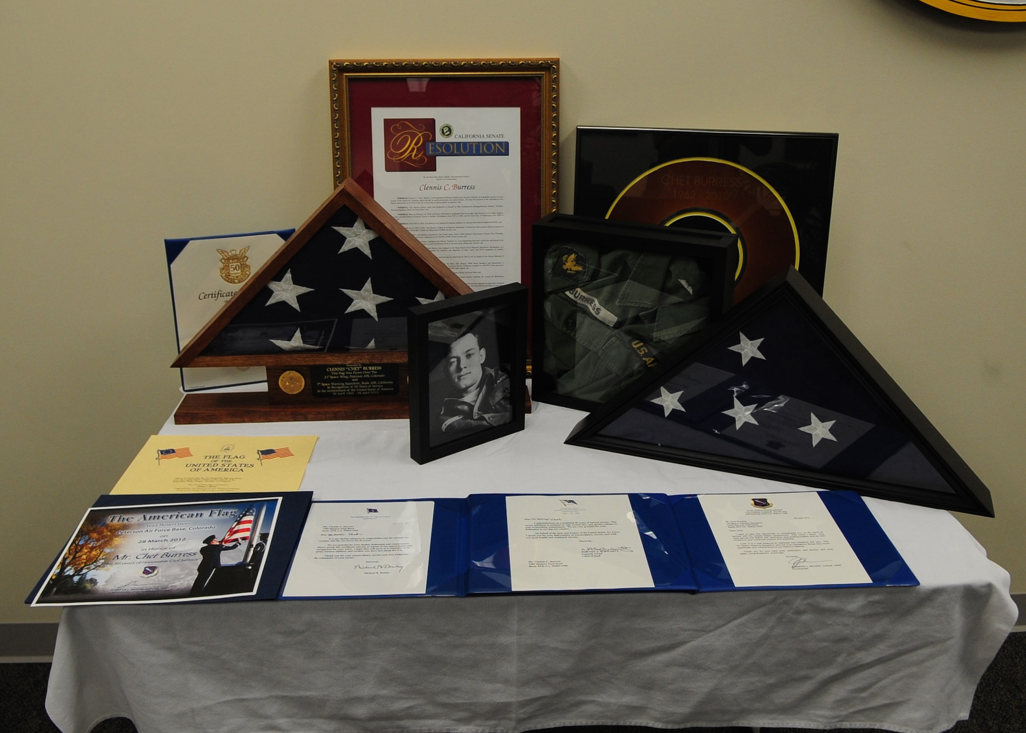 Awards and memorabilia presented to Chet Burress, 7th Space Warning Squadron ground radar systems analyst, sit on a table during a ceremony April 26 at Beale Air Force Base, Calif. Burress celebrated 50 years of federal service with no plans for retirement. (U.S. Air Force photo by Senior Airman Shawn Nickel)