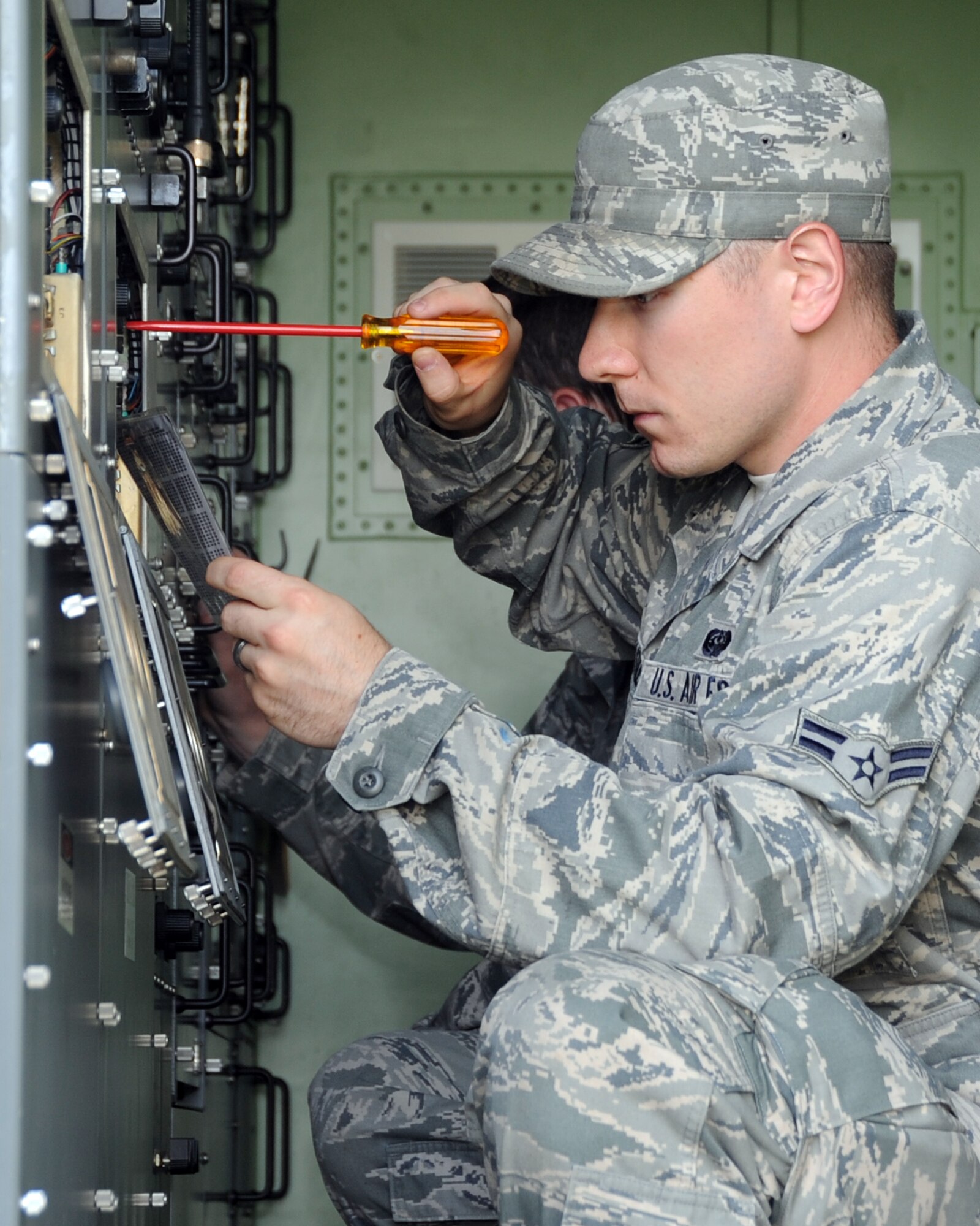 ALTUS AIR FORCE BASE, Okla. -- Airman 1st Class Andrew T. Hardcastle, 31st Combat Communication Squadron radio frequency transmission system apprentice, Tinker Air Force Base, Okla., adjusts settings inside the electrical equipment shelter of a Tropospheric Scatter Microwave Radio Terminal (TRC-170), May 1, 2012, during an exercise here. During the exercise Airmen from the 31st and 34th CCS assembled two TRC-170s, which transmitted a signal to Tinker AFB to test the range of the system. (U.S. Air Force photo by Airman 1st Class Kenneth W. Norman / Released / 97th Air Mobility Wing Public Affairs)