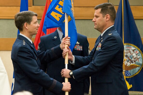 Col. John M. Devillier accepts a guideon from  Lt. Gen. Darrell Jones, Deputy Chief of Staff, Manpower, Personnel and Services, during a change of command ceremony at the Charles C. Carson Center for Mortuary Affairs May 2, 2012. Devillier assumed command of Air Force Mortuary Affairs Operations from Col. Thomas Joyce. (U.S. Air Force photo/Roland Balik)