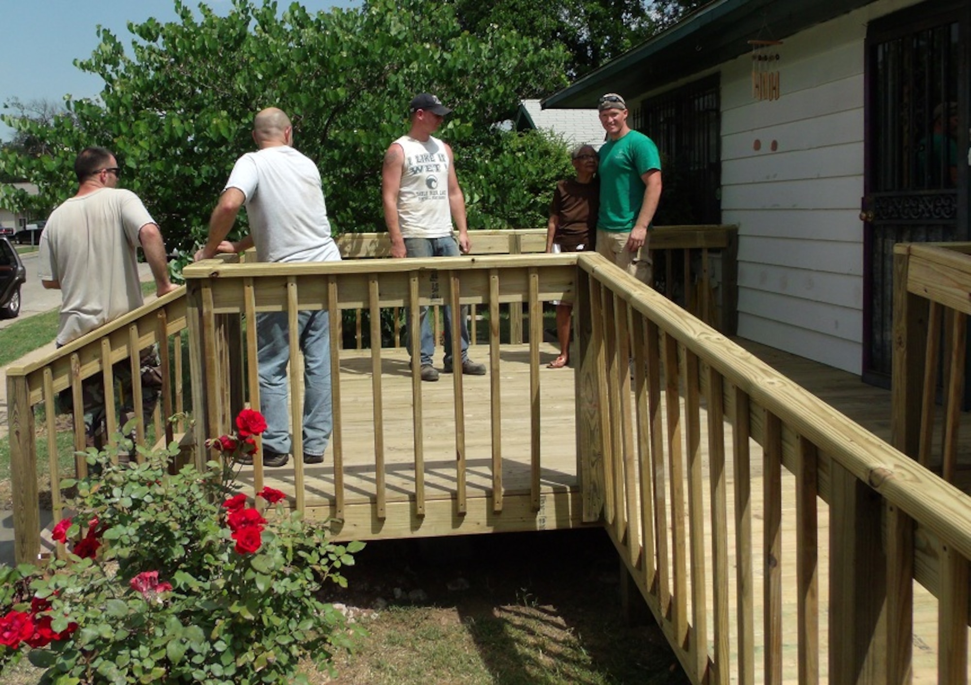 Christmas in Action 2012 team captain Jason Thompson (r), a 363rd Training Squadron nuclear weapons training instructor at Sheppard Air Force Base, stands with homeowner, Ms. Thursday, upon completion of a new porch and ramp build April 28, 2012. Sheppard volunteers combined to support 25 of the 53 home renovations for the elderly or disabled in Wichita Falls and Burkburnett, Texas. The event celebrates its 29th anniversary this year. (U.S. Air Force photo/Debi Smith)