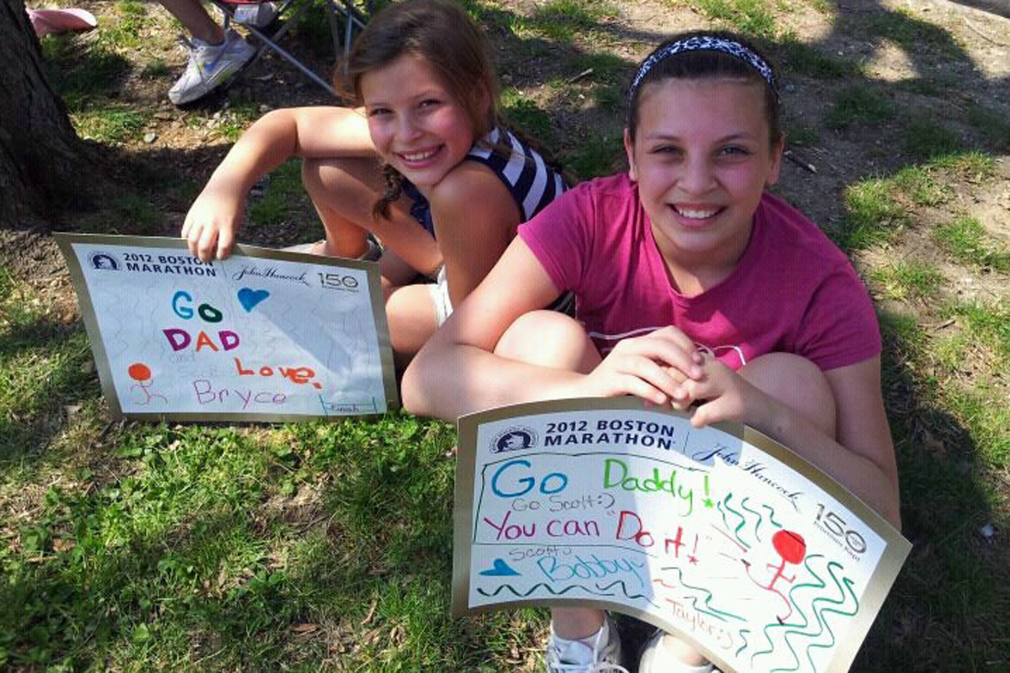 GRISSOM AIR RESERVE BASE Ind. -- Bryce, left, and Taylor Atkins cheer on their father Robert Atkins during the 116th running of the Boston Marathon. (U.S. Air Force photo)