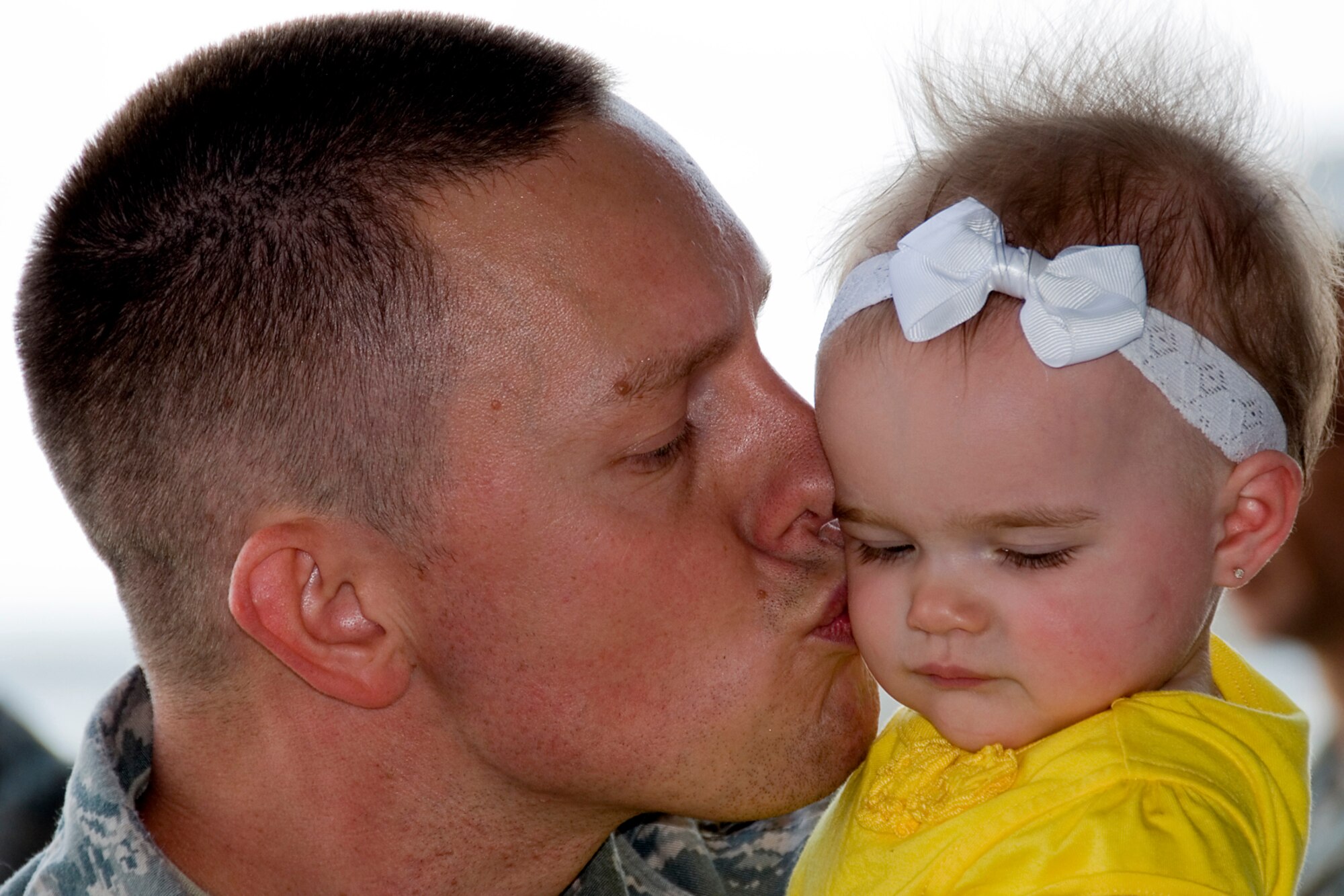 GRISSOM AIR RESERVE BASE, Ind. -- Master Sgt. Michael Morris, a client systems technician with the 434th Communications Squadron, kisses daughter Mila upon his return from a deployment May 2. (U.S. Air Force photo/Tech. Sgt. Douglas Hays)