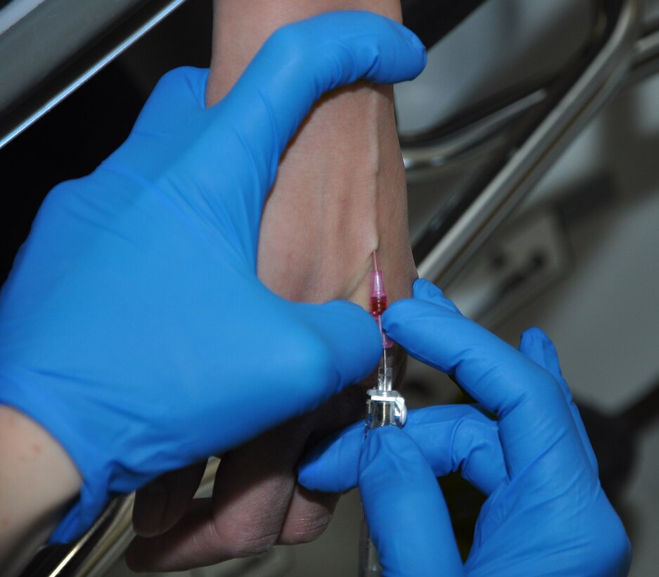 U.S. Air Force 1st Lt. Casey Langworthy, 633rd Medical Group registered nurse, inserts an IV needle into the hand of Tech. Sgt. Angela Biggs, 633rd Surgical Operations Squadron NCO in charge of women’s health, in preparation for surgery at USAF Hospital Langley, May 2, 2012. Biggs suffered both an injury to her elbow, and a traumatic brain injury during her deployment to Afghanistan.  (U.S. Air Force photo by Senior Airman Jarad A. Denton/Released)