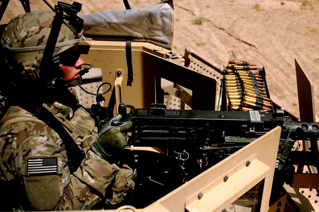 U.S. Army Spc. Christopher Fox, rifleman, secures an area in a Mine Resistant Ambush Protected turret during a construction site quality assurance inspection in Shinkai, Afghanistan, Aug. 18, 2011. After returning from Afghanistan, Fox flew from his home in Boston to support U.S. Air Force Tech. Sgt. Angela Biggs during her surgery at USAF Hospital Langley. (U.S. Air Force photo by Senior Airman Grovert Fuentes-Contreras/Released)