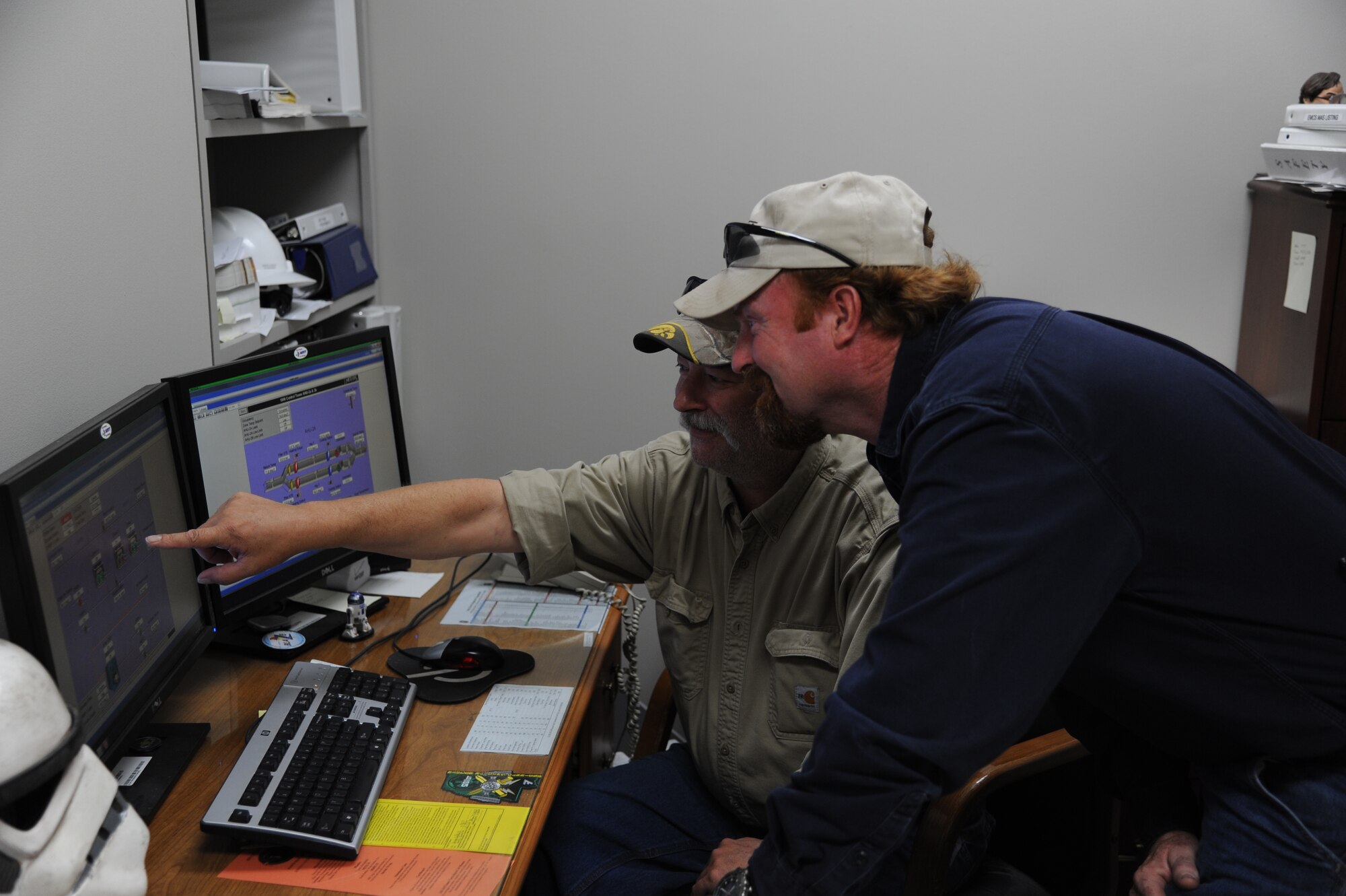 John Enyart, Energy Management and Control Systems shows Rick Stewart Sr., Heating, Ventilation and Air Conditioning how to manage HVAC systems on the EMCS screen.  The EMCS allows for management of most HVAC systems on Columbus Air Force Base and tells if the system is functioning properly.  (U.S. Air Force Photo/Airman 1st Class Charles Dickens)