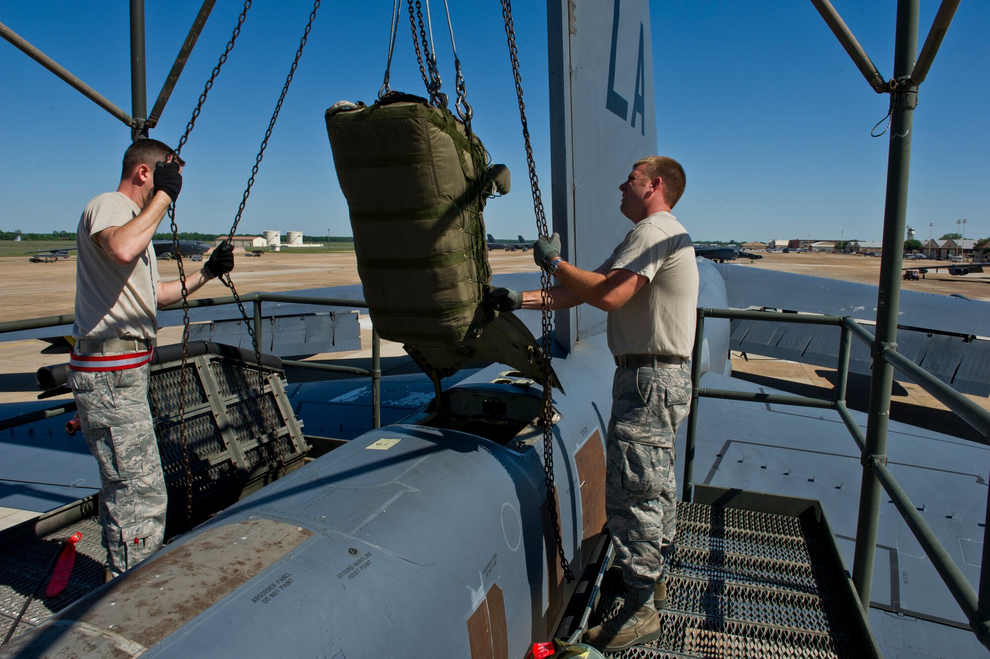 BARKSDALE AIR FORCE BASE, La. - Staff Sgt. Brad Davis and Tech. Sgt. Kevin Rowe, 96th Aircraft Maintenance Unit crew chiefs, lower a new drag chute into the tail of a B-52H Stratofortress at Barksdale Air Force Base, La., April 18, 2012. The drag chute is a parachute that is deployed after landing to help the B-52H slow down. (U.S. Air Force photo/Senior Airman Marleah Miller) 