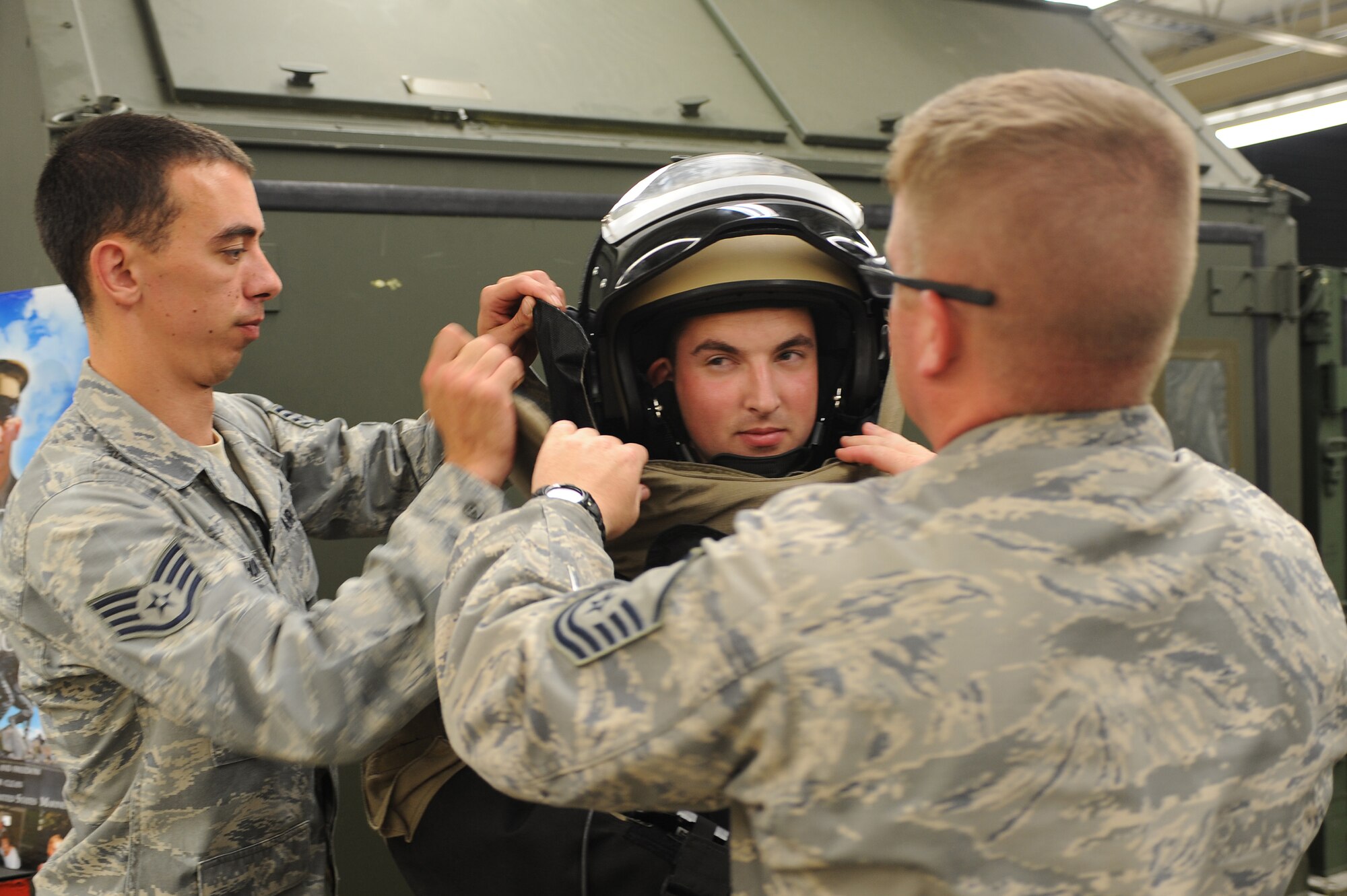 U.S. Air Force Staff Sgt. Derek Horn (left) and Master Sgt. Christopher Wakham (right) help Airman 1st Class Maurice Aldrich don an explosive ordnance disposal 9-bomb disposal suit during an EOD open house on Seymour Johnson Air Force Base, N.C., May 1, 2012. Visitors were given the opportunity to wear the same suit that EOD technicians wear in the field. Horn, 4th Civil Engineer Squadron EOD apprentice, is from Atlanta. Wakham, 4th CES NCO in-charge of EOD flight, hails from Lewisburg, Tenn. Alrich, 4th Component Maintenance Squadron avionics apprentice, is from Erie, Pa. (U.S. Air Force photo/Airman 1st Class John Nieves Camacho/Released)