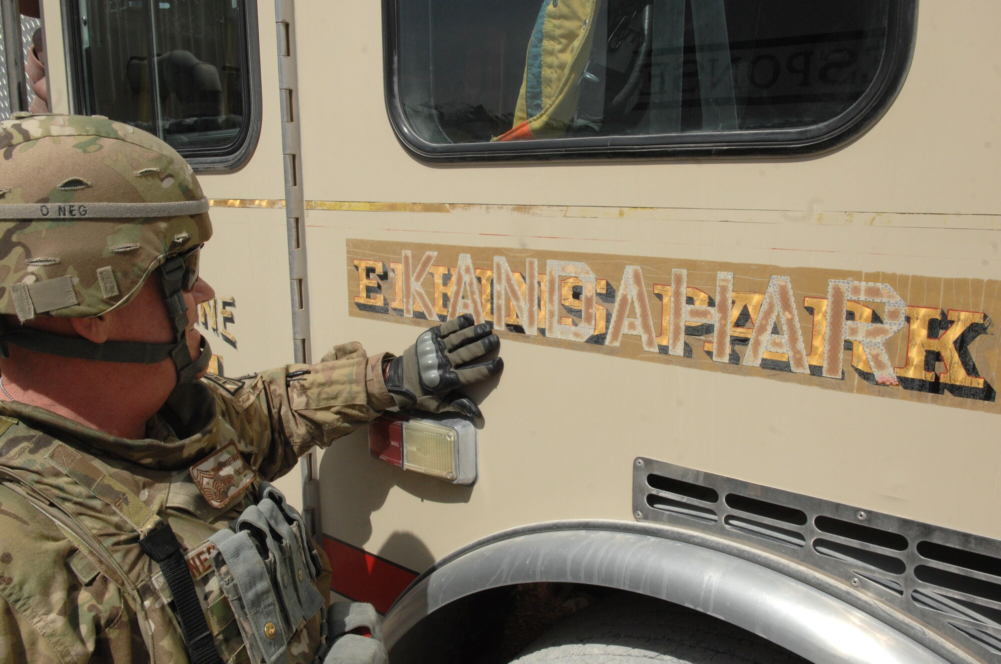 Chief Master Sgt. John Hoffman, 438th Air Expeditionary Wing command chief, runs his hand over lettering painted on a fire truck April 5, at Kandahar Air Base, Afghanistan. The truck and the chief both shared a past history of service for the Elkins Park, Pa., Volunteer Fire Department. (U.S. Air Force photo by Tech. Sgt. Jeremy Larlee)
