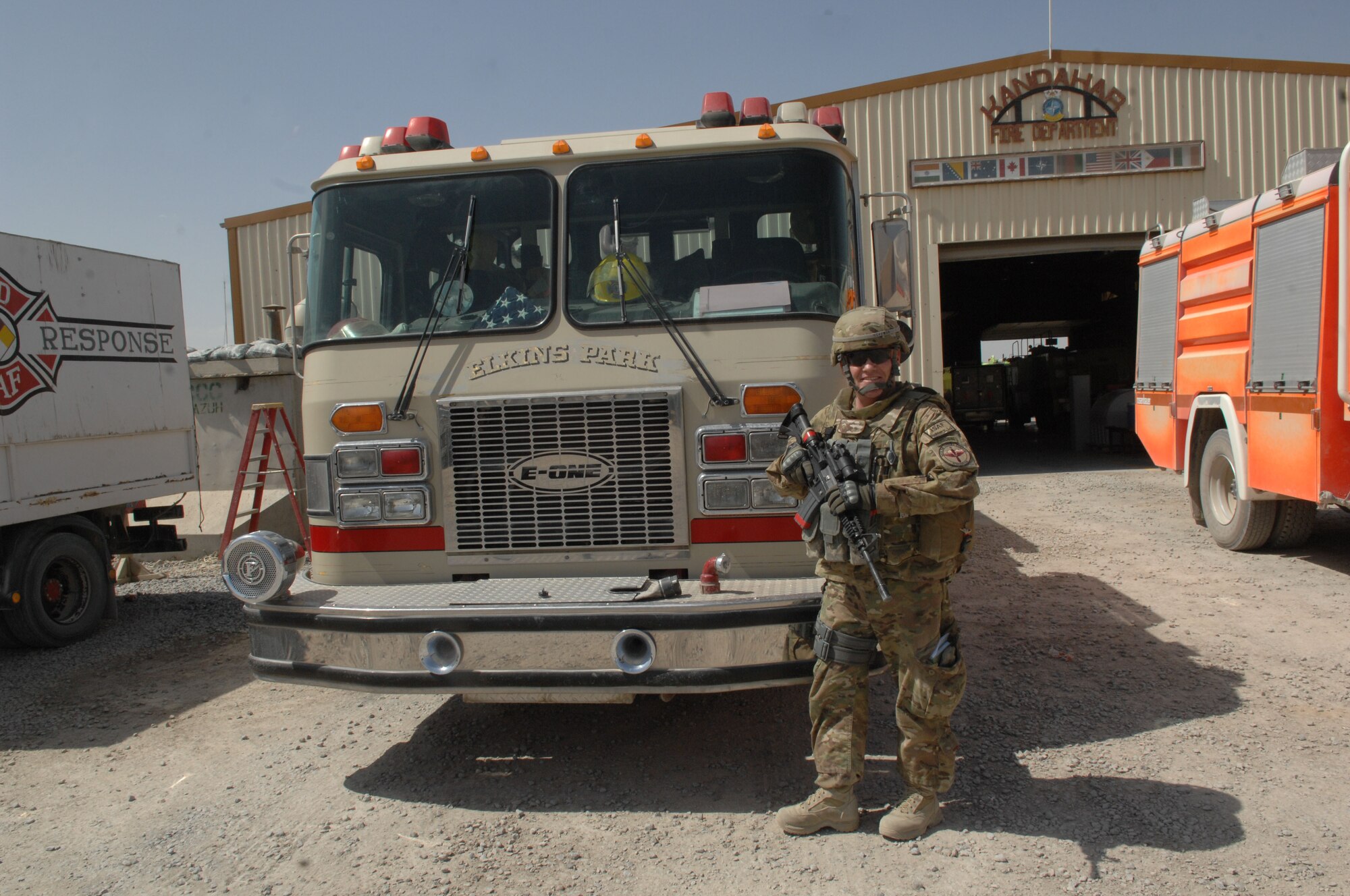 Chief Master Sgt. John Hoffman, 438th Air Expeditionary Wing command chief, poses in a front of a fire truck April 5, at Kandahar Air Base, Afghanistan. The truck and the chief both shared a past history of service for the Elkins Park, Pa., Volunteer Fire Department. (U.S. Air Force photo by Tech. Sgt. Jeremy Larlee)