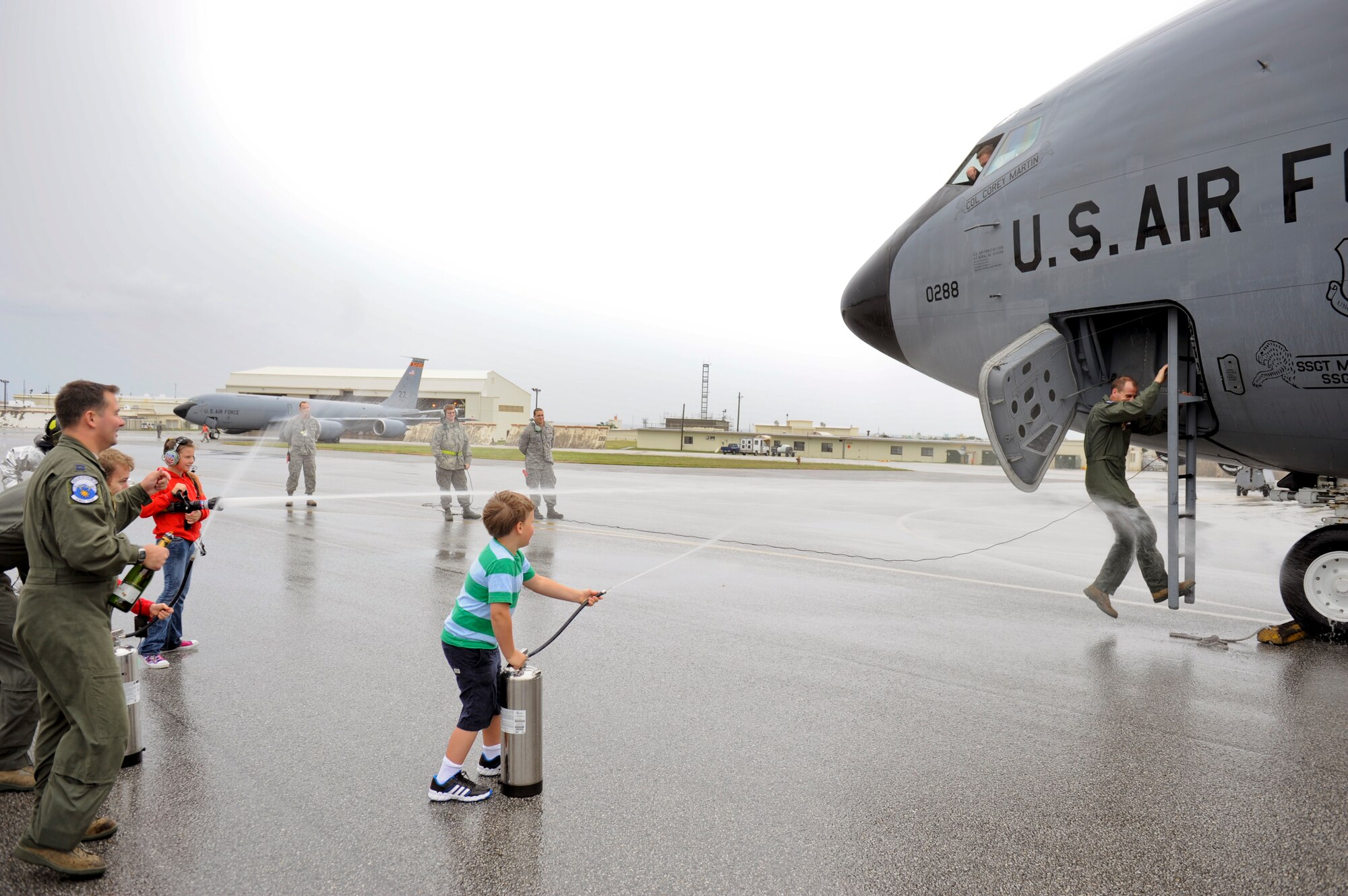 U.S. Air Force Col. Corey Martin, 18th Wing vice commander, climbs out of the cockpit of U.S. Air Force KC-135 Stratotanker refueling aircraft and is sprayed down by friends and family following his “fini” flight on Kadena Air Base, Japan, April 18. Martin served as the wing vice commander from May 2011. (U.S. Air Force photo/ Airman 1st Class Maeson L. Elleman)