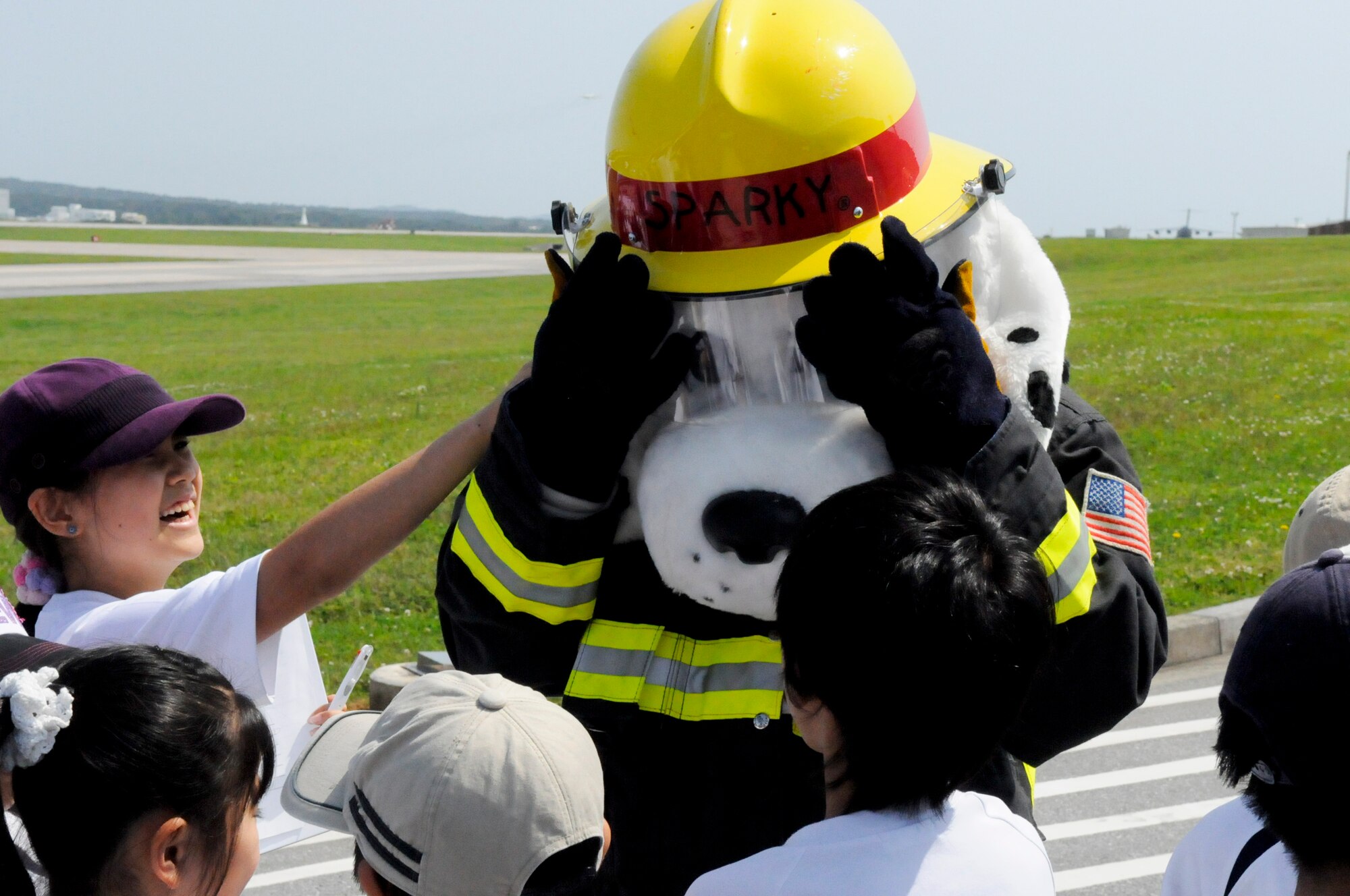 Sparky the fire dog entertains fourth graders from a local off-base school during a tour of the fire headquarters building at Kadena Air Base, Japan, April 27, 2012. During the tour, children were shown firefighter gear, fire trucks, fire hoses, and a demonstration how firefighters respond to a real fire call. (U.S. Air Force photo/Airman Tara A. Williamson)