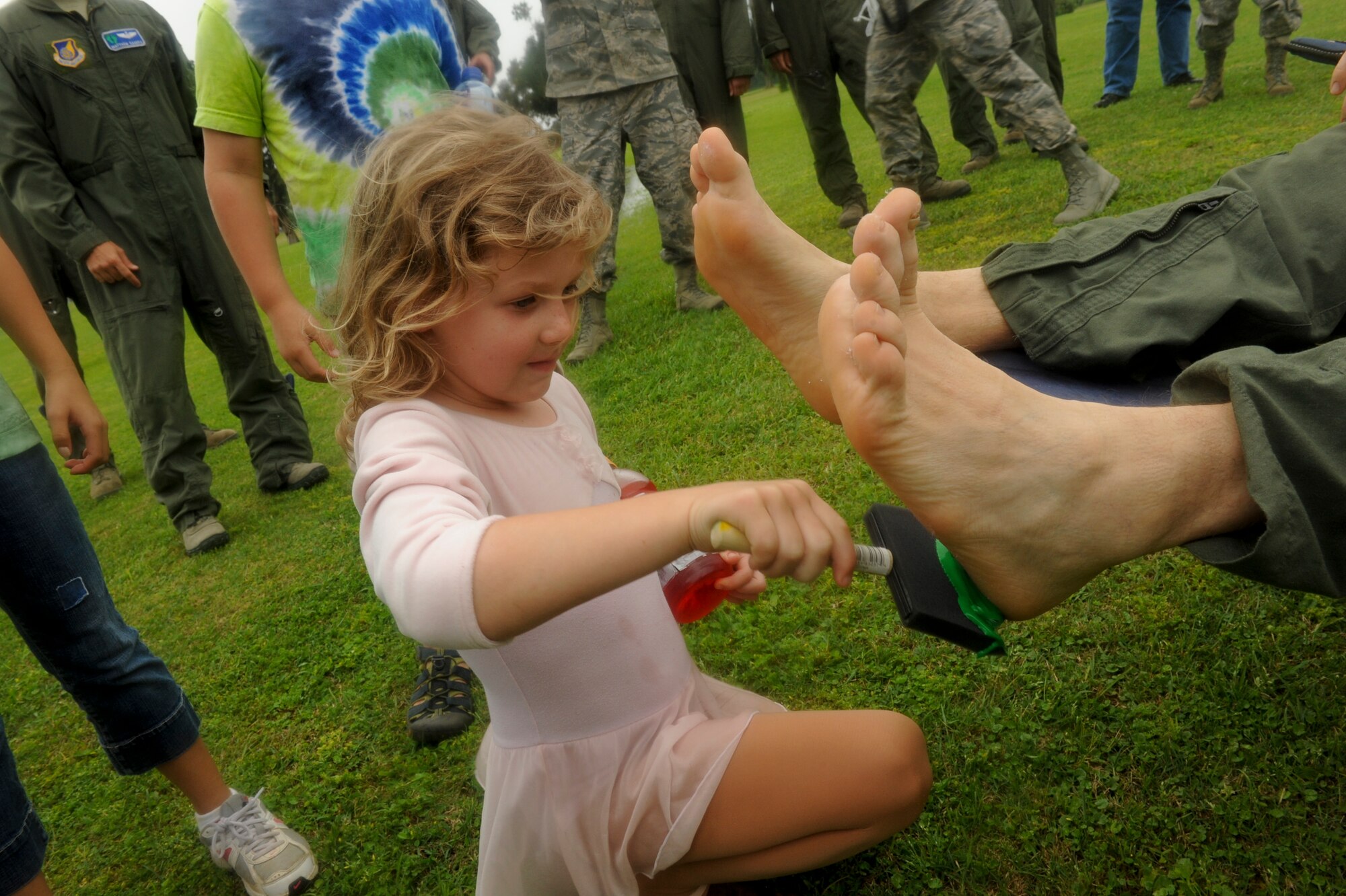 18th Wing vice commander, U.S. Air Force Col. Corey Martin’s youngest daughter paints his feet green after a “fini” flight with the 33rd Rescue Squadron on Kadena Air Base, Japan, May 2, 2012. Along with being the vice commander of the 18th Wing, Martin has served as a C-141 and C-17 examiner airdrop aircraft commander, chief of wing safety, squadron commander and in various staff assignments at the major command and combatant command level. (U.S. Air Force by Airman 1st Class Brooke P. Beers/Released)