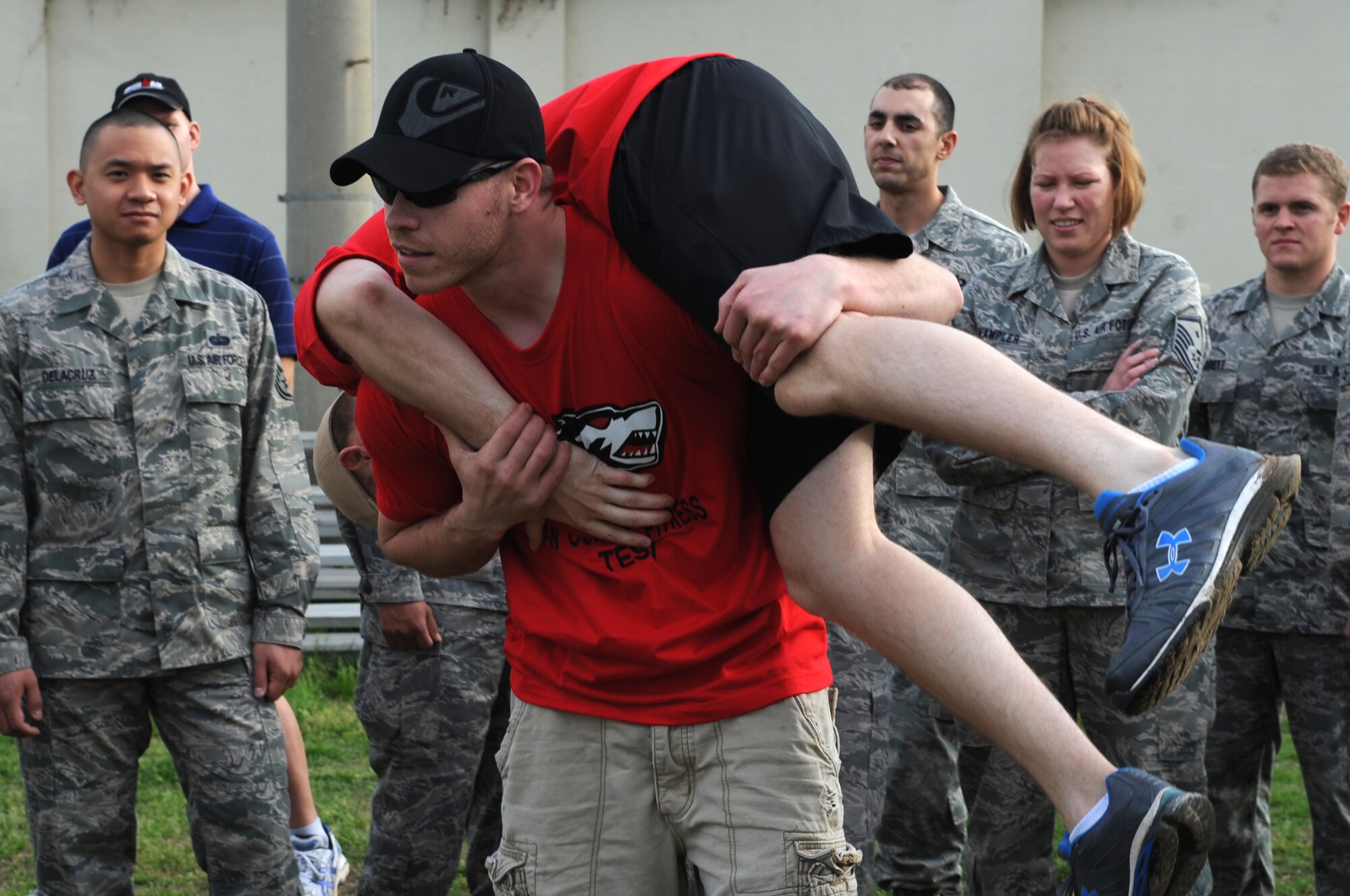 Instructors demonstrate a fireman’s carry before leading participants through a combat fitness test May 2, 2012, at Kunsan Air Base, Republic of Korea. Each instructor must score 270 out of 300 points on the test before being qualified to lead the test. (U.S. Air Force photo/Senior Airman Brigitte N. Brantley)