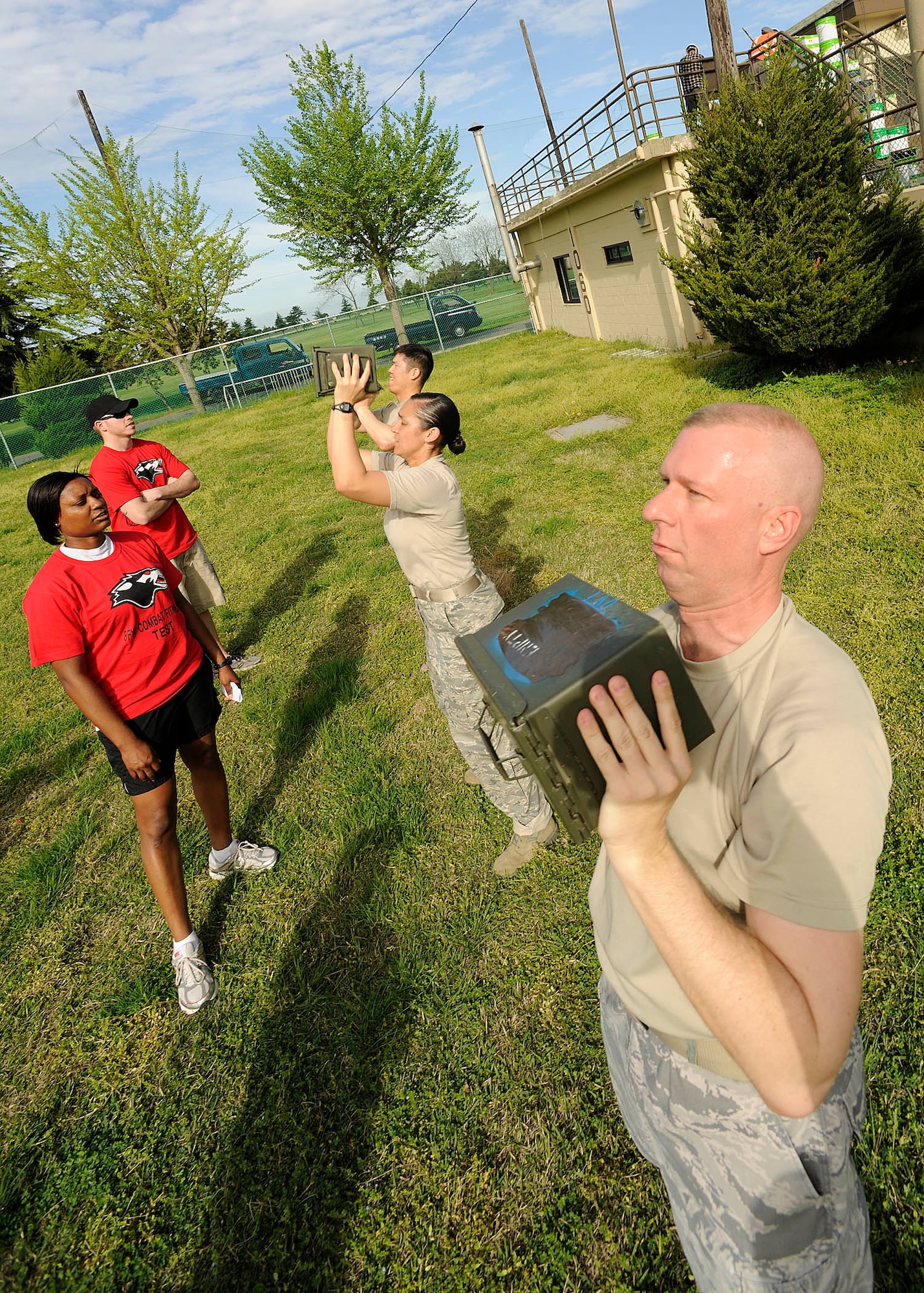 Airmen from the 8th Fighter Wing lift 30-pound ammo cans above their heads as many times as they can in two minutes during a combat fitness test held May 2, 2012, at Kunsan Air Base, Republic of Korea. Although men and women complete the same tasks, their scores are scaled differently. (U.S. Air Force photo/Staff Sgt. Rasheen Douglas)