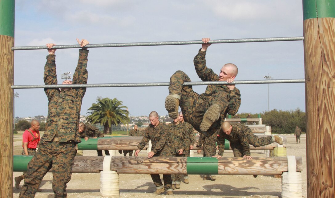 Company A recruits use all their upper body strength to get over the double bars aboard Marine Corps Recruit Depot San Diego May 3. This was one of the many events recruits had to complete while taking on the Obstacle Course during week two. After the double bars recruits climb the rope, which can be extra challenging after completing the whole O-Course since it requires a lot of upper body strength.