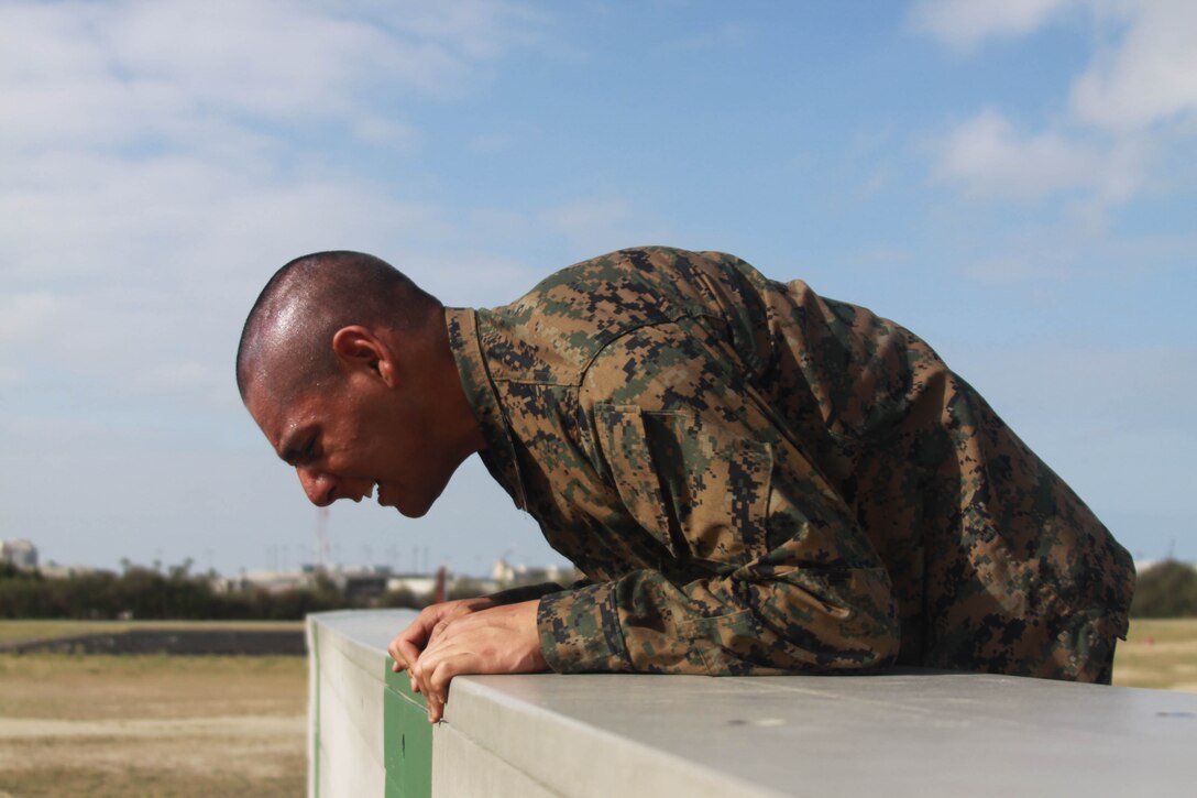 A Company A recruits tries to climb over a wall aboard Marine Corps Depot San Diego May 3. This was one of the many events recruits had to complete while taking on the Obstacle Course during week two. Many of the obstacles on the course required Co. A recruits to use a large amount of their upper body strength.