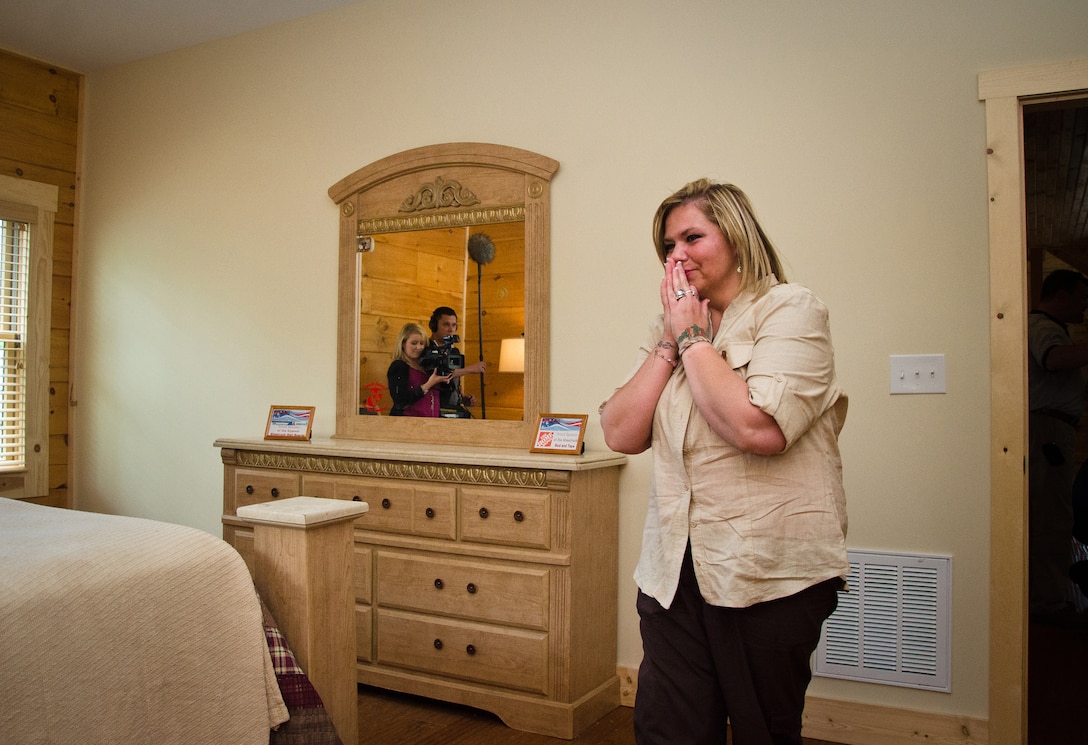 Jamie Gizzarelli holds back tears as she tours her family's brand new house, Jacksonville, N.C., Apr. 28. The house was built using supplies and donations from local businesses and various veterans' groups. Gizzarelli was medically retired from the Marine Corps after suffering traumatic brain injury and shrapnel wounds from multiple IED blasts that he sustained on his second tour to Iraq.
