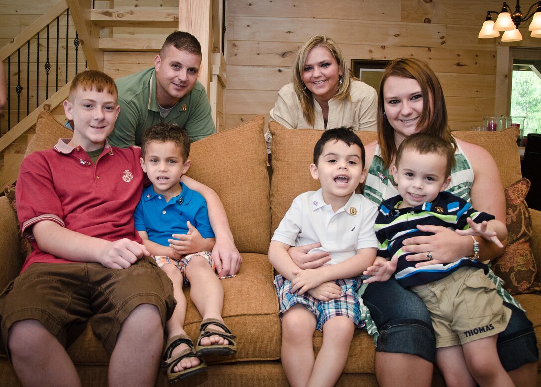Retired Marine Staff Sergeant Vincent Gizzarelli (top left) poses for a photo with his family in their brand new house, Jacksonville, N.C., April 28. The house was built using supplies and donations from local businesses and various veterans' groups. Gizzarelli was medically retired from the Marine Corps after suffering traumatic brain injury and shrapnel wounds from multiple IED blasts that he sustained on his second tour to Iraq.
