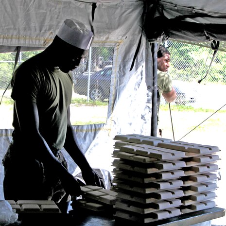 A food service specialist with Food Service Company, Combat Logistics Regiment 27, 2nd Marine Logistics Group stacks trays in preparation of a meal served during a training exercise aboard Camp Lejeune, N.C., May 3, 2012.  The entire company supported the Battle Skills Training School for two days in order to practice their efficiency in the field and proficiency of skills.  (U.S. Marine Corps photo by Cpl. Katherine M. Solano)