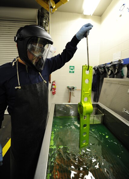 Tech. Sgt. Brian Gregory, 141st Maintenance Squadron non-destructive inspection technician, dips a helicopter part from a in a UH-1 Huey, into a chemical that will cause the item to glow under a black light to reveal any cracks at Fairchild Air Force Base, Wash., April 26, 2012. Through the use of specialized equipment, Gregory can identify cracks and other defects in metal that could cause catastrophic failure in flight. (U.S. Air Force photo by Airman 1st Class Taylor Curry/Released)
