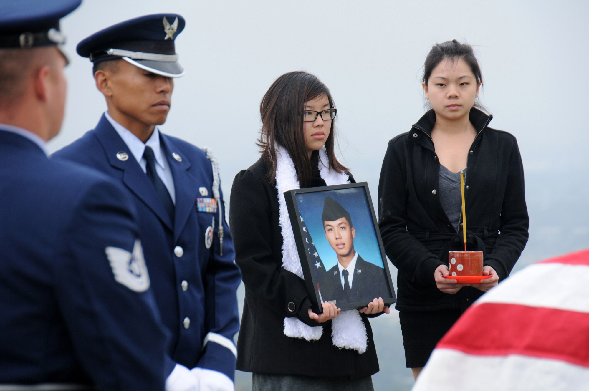 Members of the Blue Eagles Honor Guard, a “total force honor guard” comprised of Air Force military members from Los Angeles and Edwards Air Force Bases and March Air Reserve Base, stand alongside Staff Sgt. Ho Tak “William” Leung’s cousins Krystal Chu, holding the photo, and Sofi Lam. Air Force photo by Joe Juarez.
