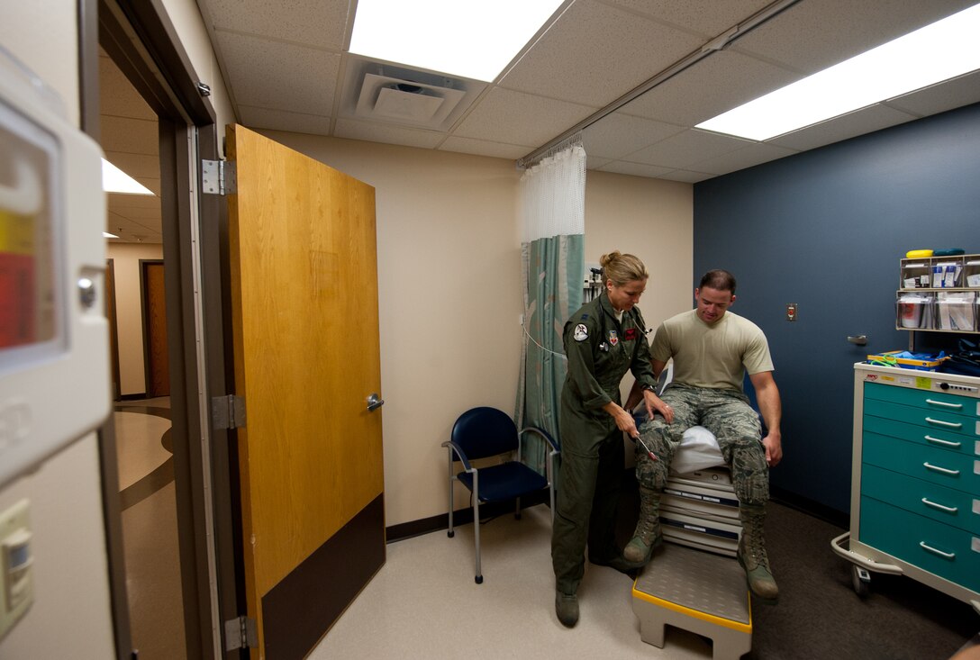 Capt. Sarah Freidel, 34th Bomb Squadron flight surgeon, checks the patella tendon reflex of Staff Sgt. Jacob Appleby, 28th Medical Operations Squadron ambulance services technician, during a physical exam in the flight medicine clinic on Ellsworth Air Force Base, S.D., May 2, 2012. Flight medicine is responsible for determining if Airmen in high stress career fields are fit and stable enough to perform their duties, and provides them with help or advice if they are deemed unfit. (U.S. Air Force photo by Airman 1st Class Kate Thornton/Released)