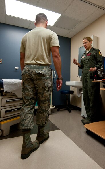 Capt. Sarah Freidel, 34th Bomb Squadron flight surgeon, analyzes Staff Sgt. Jacob Appleby, 28th Medical Operations Squadron ambulance services technician, while he performs exercises during a physical exam in the flight medicine clinic on Ellsworth Air Force Base, S.D., May 2, 2012. Various tests are performed during the exam to ensure that all of the Airmen assessed are able and ready to perform their highly-stressful duties. (U.S. Air Force photo by Airman 1st Class Kate Thornton/Released)
