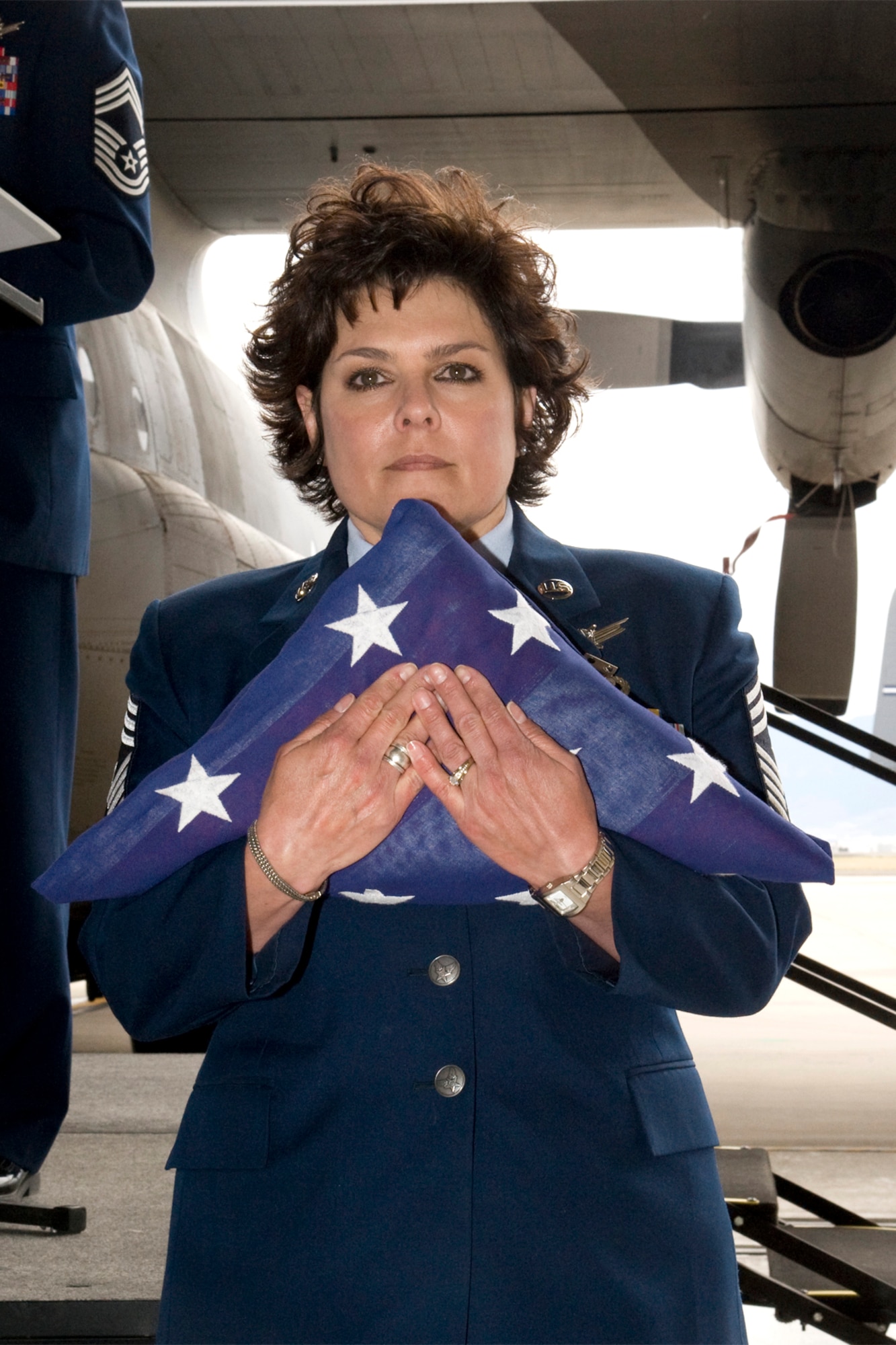 302nd Airlift Wing Command Chief Master Sgt. Suzette Cherry holds the flag presented to her during her retirement ceremony at Peterson Air Force Base, Colo. on April 14. Cherry retired after 25 years of service to the U.S. Air Force. (U.S. Air Force photo/Craig Denton)