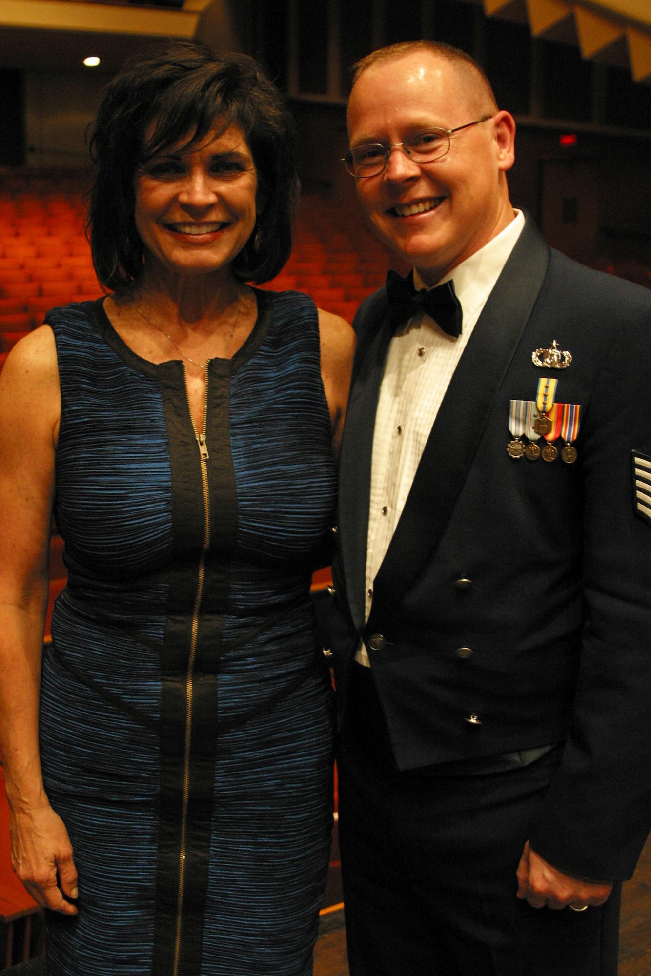 Technical Sergeant Scott Sauer, trumpeter and productions NCOIC with the Band of Mid-America, poses with Janine Sijan-Rozina, sister of the late POW U.S. Air Force Captain Lance Sijan. TSgt Sauer was instrumental in coordinating Ms. Sijan-Rozina's attendance at the band's final concert at Milwaukee’s Marcus Center. (U.S. Air Force Photo by TSgt Keisha Gwin-Goodin)